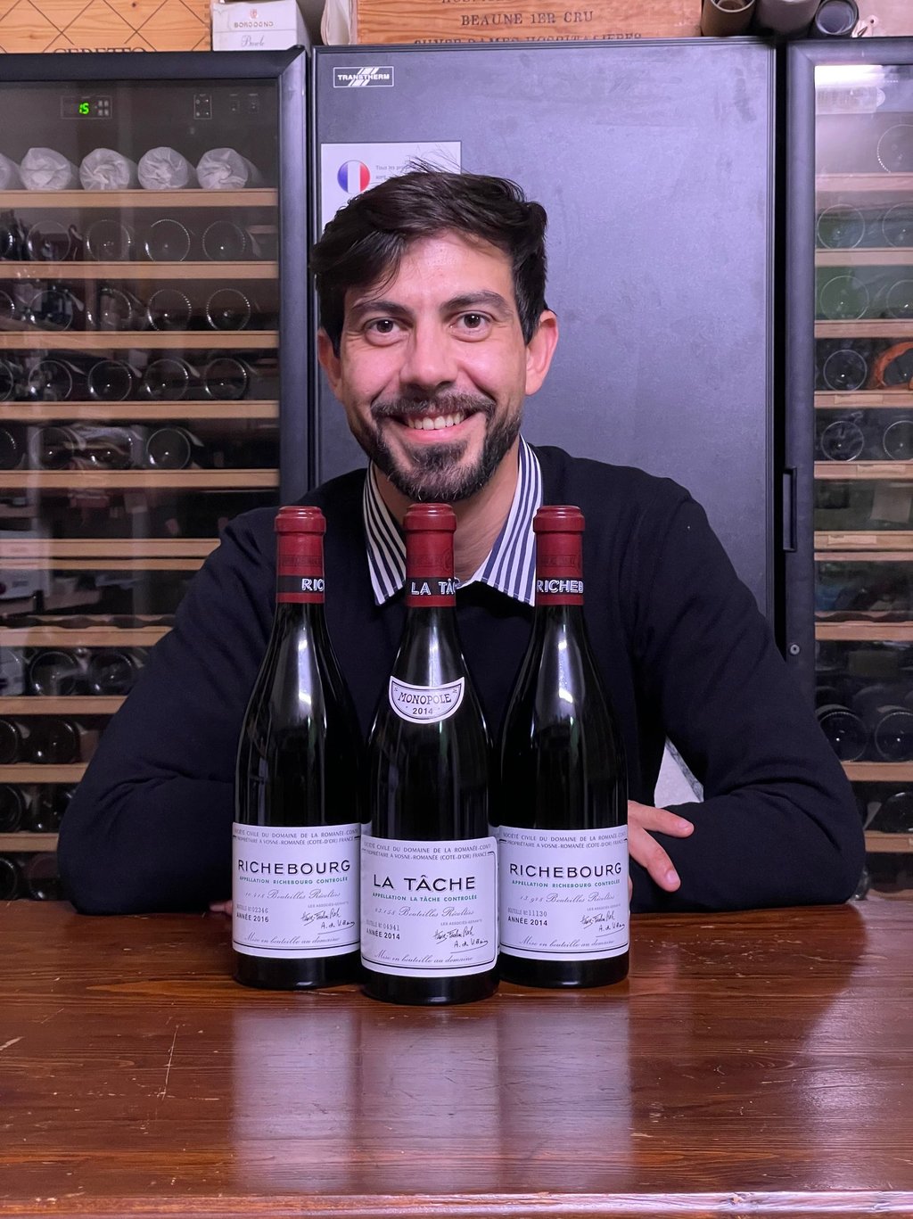 a man in a sweater and sweater with a wine bottle