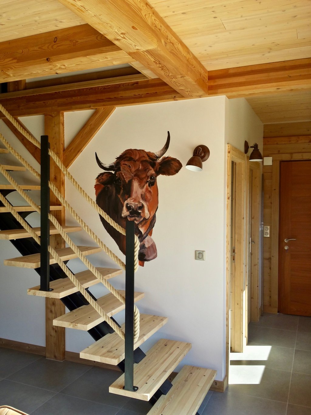 Reproduction d'un tableau (une tête de vache), sur le mur d'un escalier pour un chalet locatif. Création d'une ambiance.