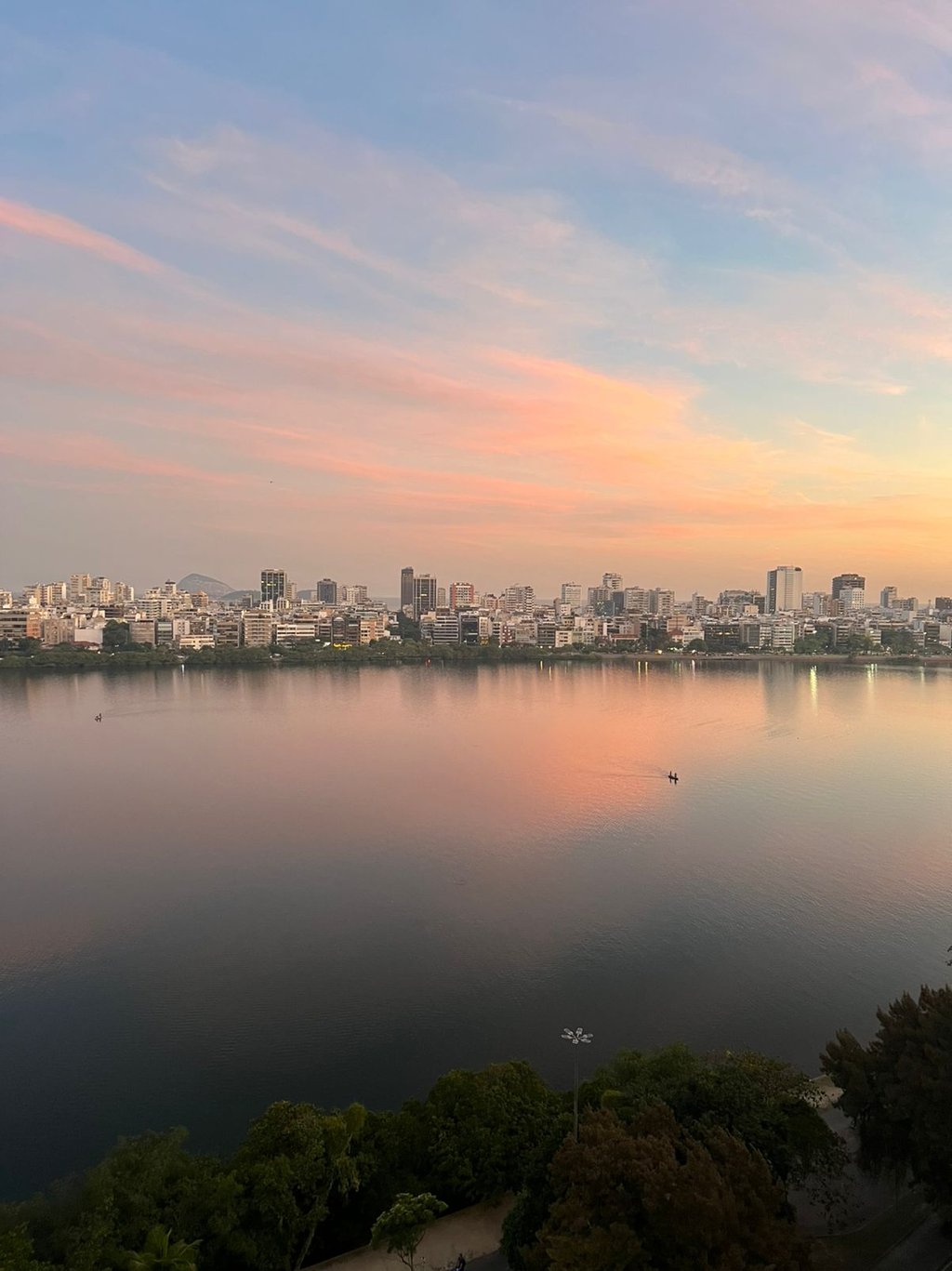 a city skyline with a river and a boat in the water