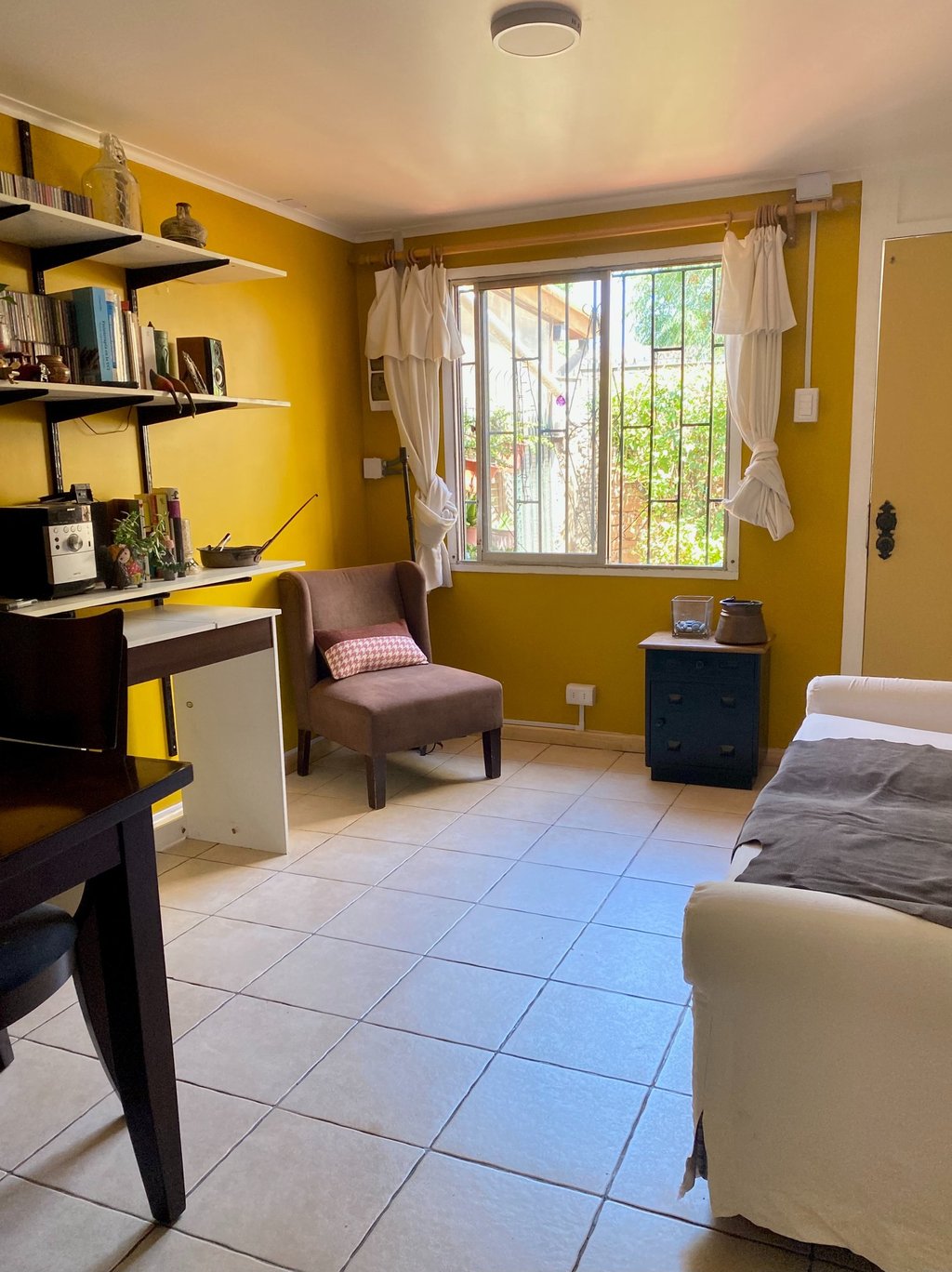 Interior de sala de estar con paredes amarillas y zona de trabajo | proyecto del Studio Atípico