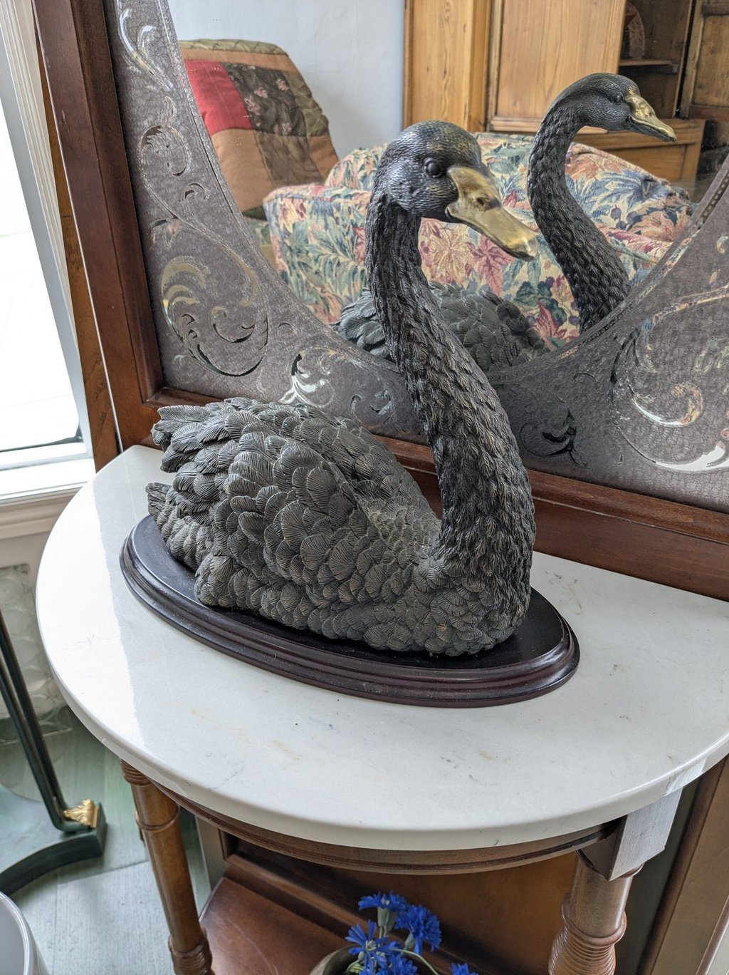 a swan - shaped sculpture of a swan with a mirror in the background