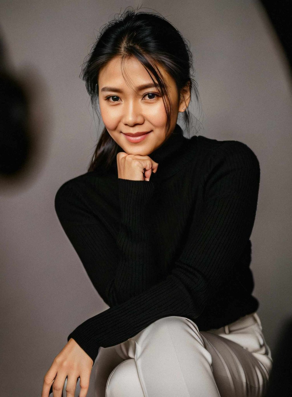 a woman in a black sweater and white pants