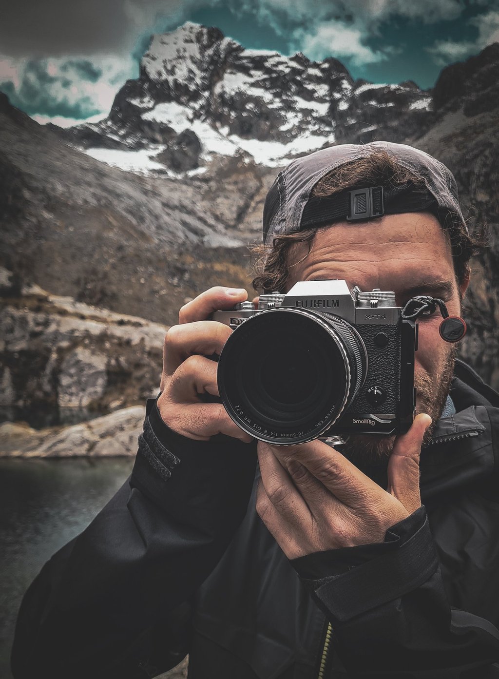 Fotografia di Marco Maggini mentre tiene in mano la macchina fotografica in montagna