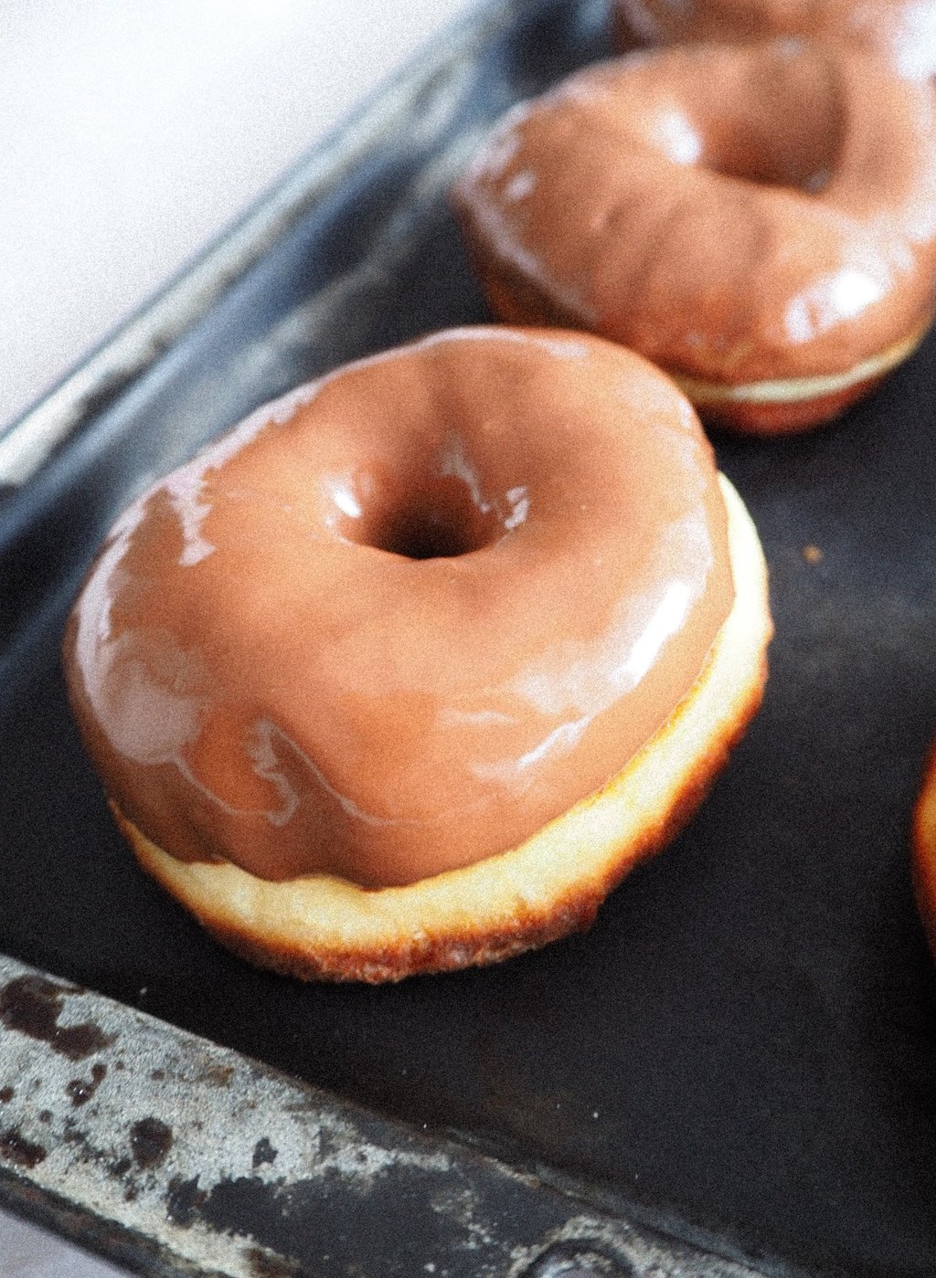 zbliżenie na pączek z dziurką z polewą z mlecznej czekolady