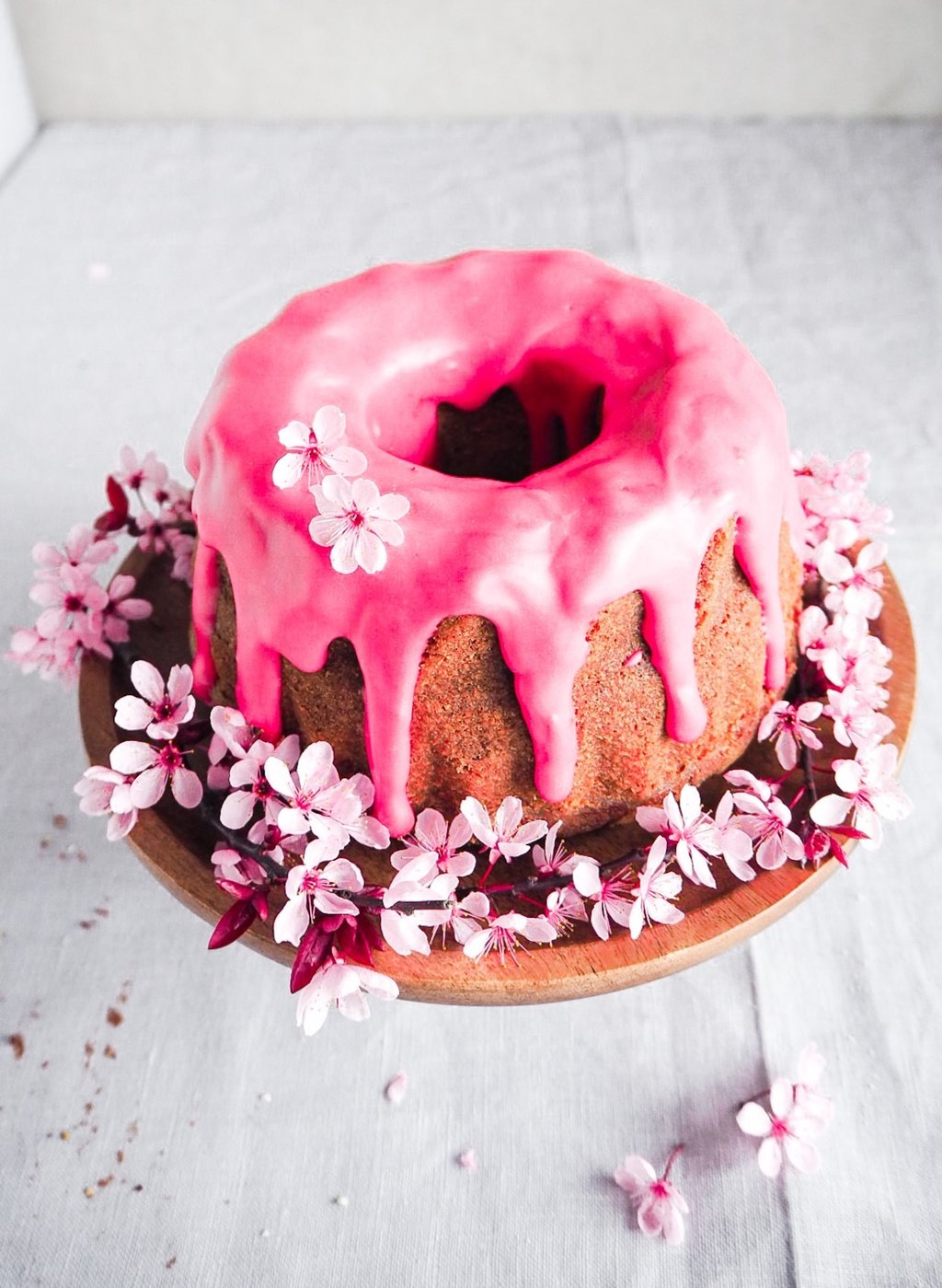 babka z malinowym lukrem udekorowana kwiatami wiśni