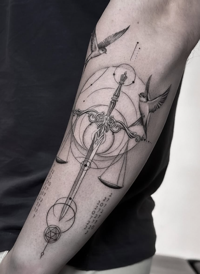 Tatuaje fineline balanza de la justicia con golondrinas en antebrazo madrid