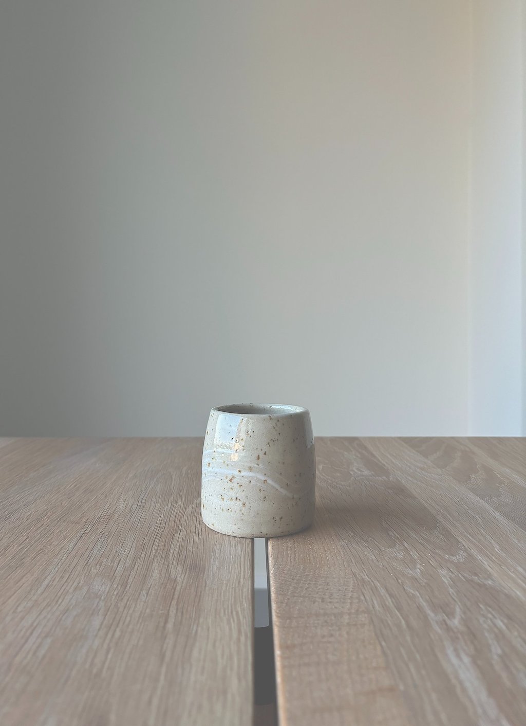 Kleiner, heller Keramikbecher im Japandi-Stil