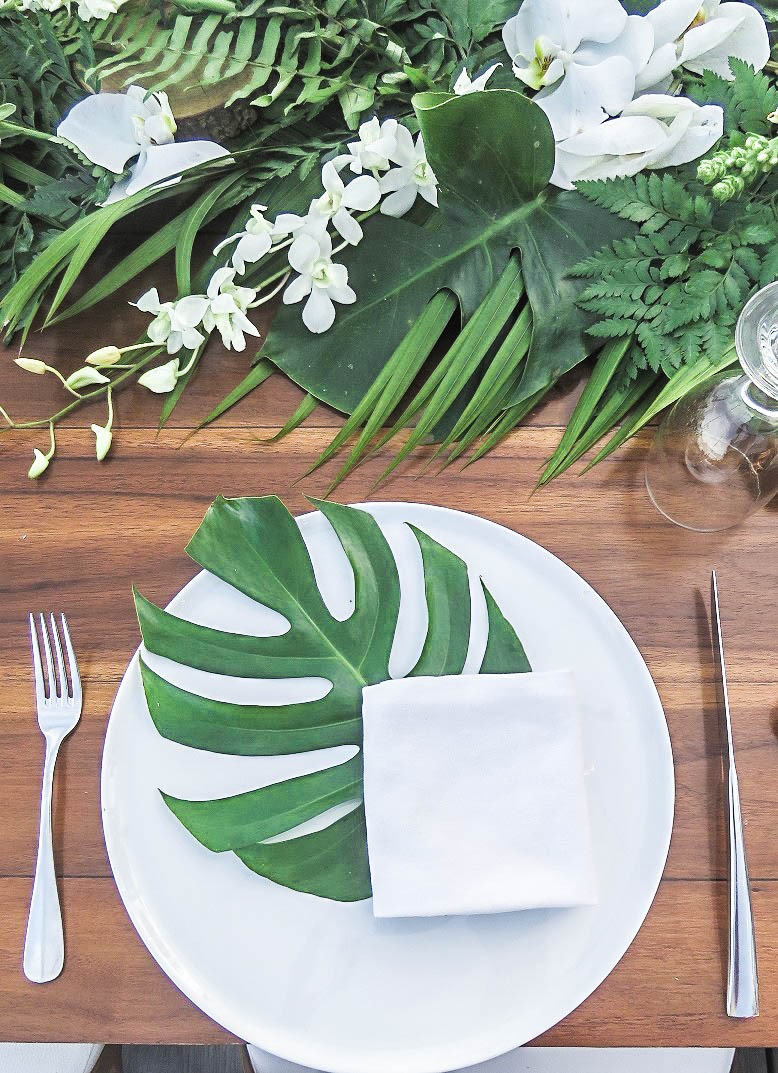 simple and elegant wedding reception plate decor with tropical leaf