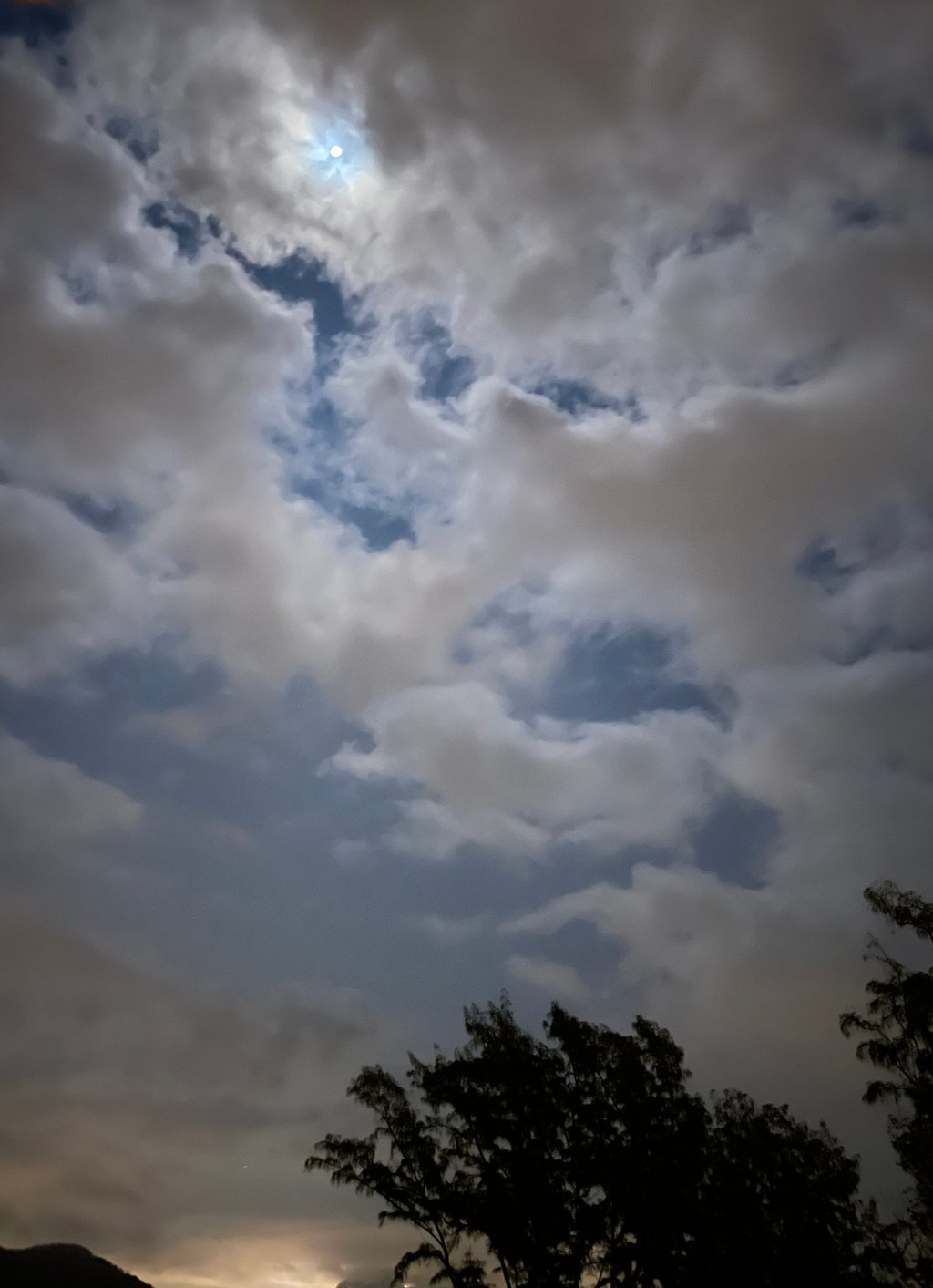 a cloudy sky with a few clouds and a few trees