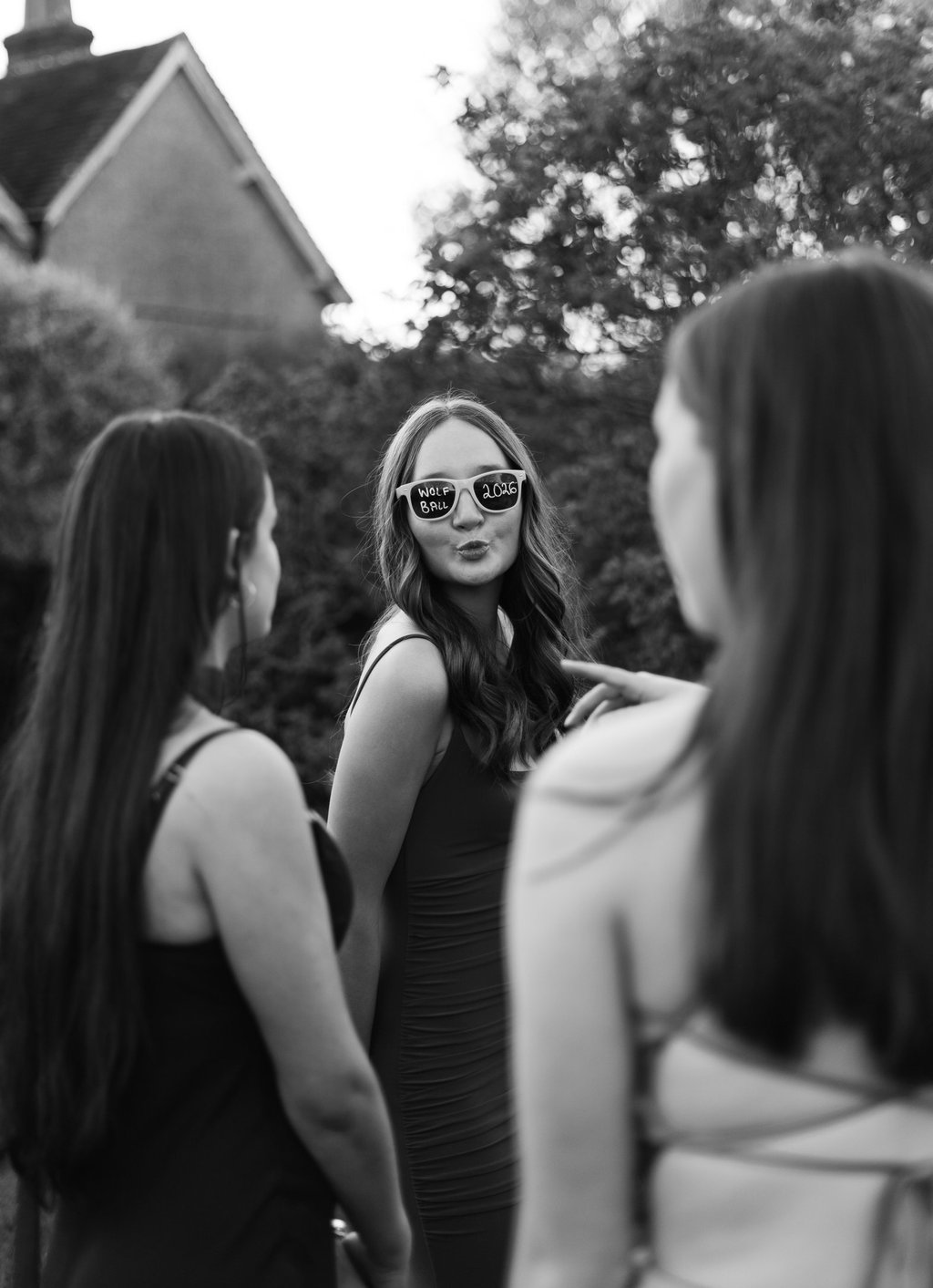 black and white image of a girl with sunglasses looking and the camera