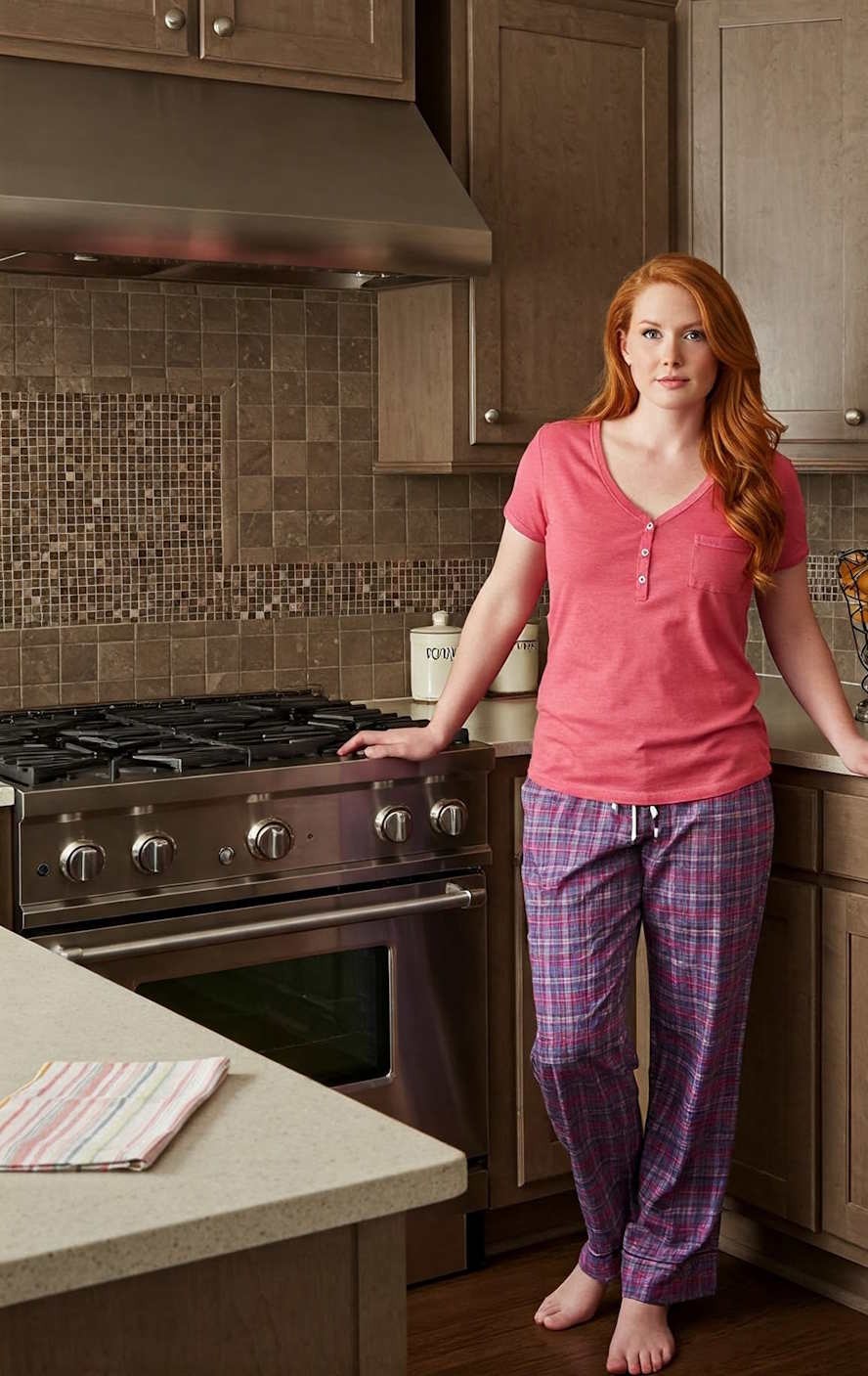 attractive housewife in pajamas in kitchen