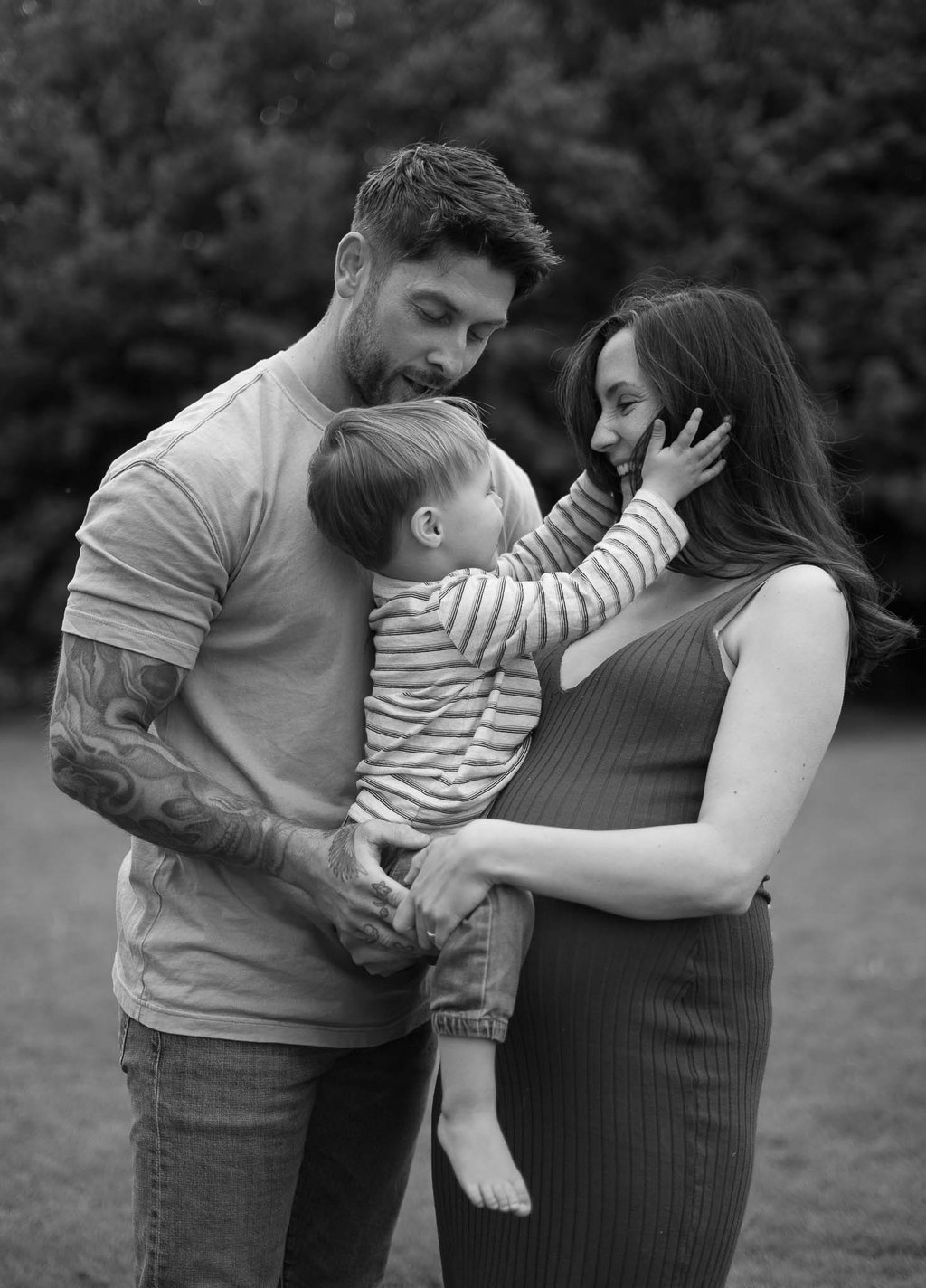 Black and white photo of a family pregnant mother holding her son 