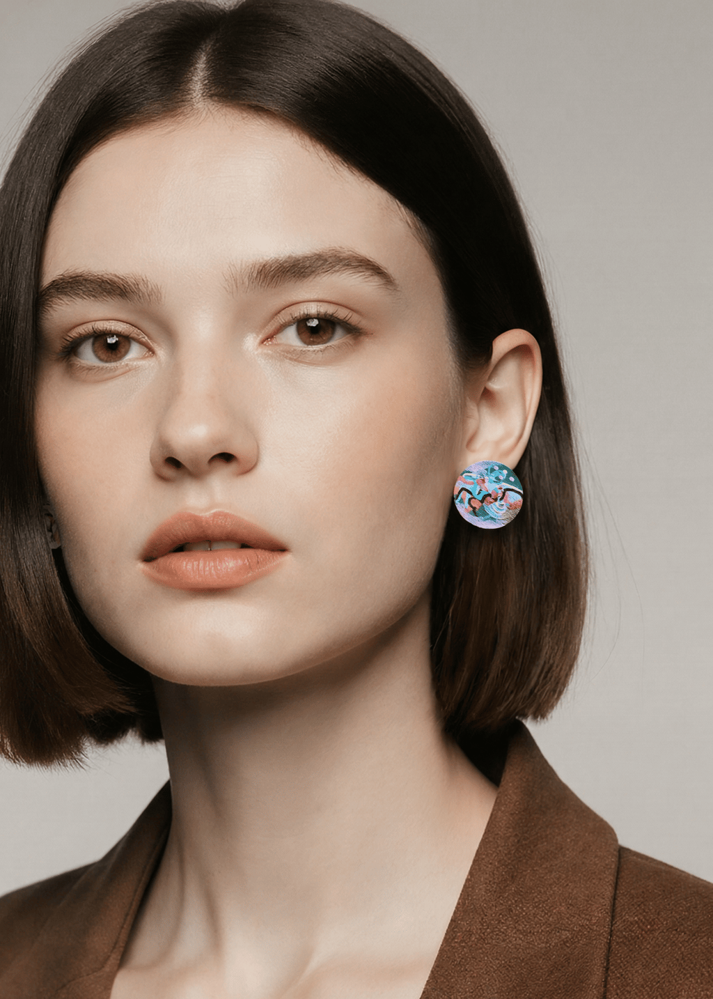 Woman with brown hair wearing colourful handpainted earrings 