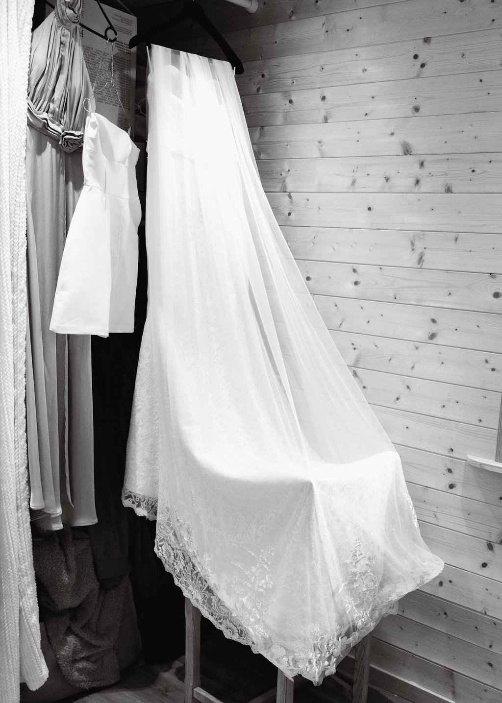 Élégant long voile de mariée blanc bordé de dentelle, drapé sur une chaise dans un dressing rustique