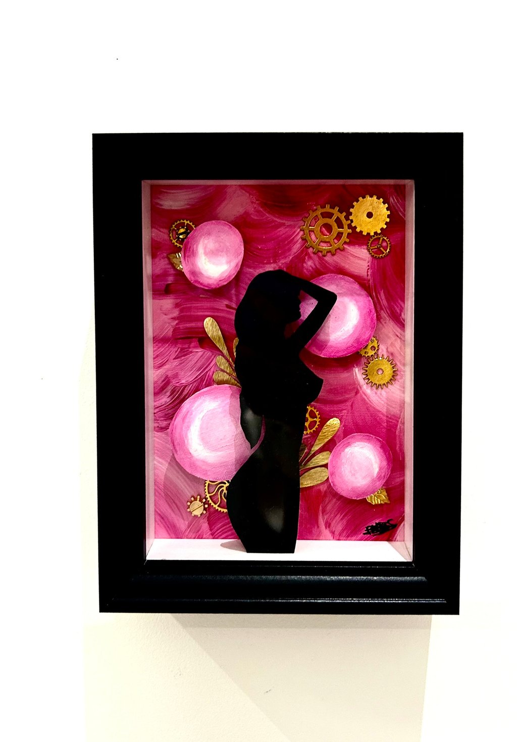 a woman in a black dress standing in front of a pink flower