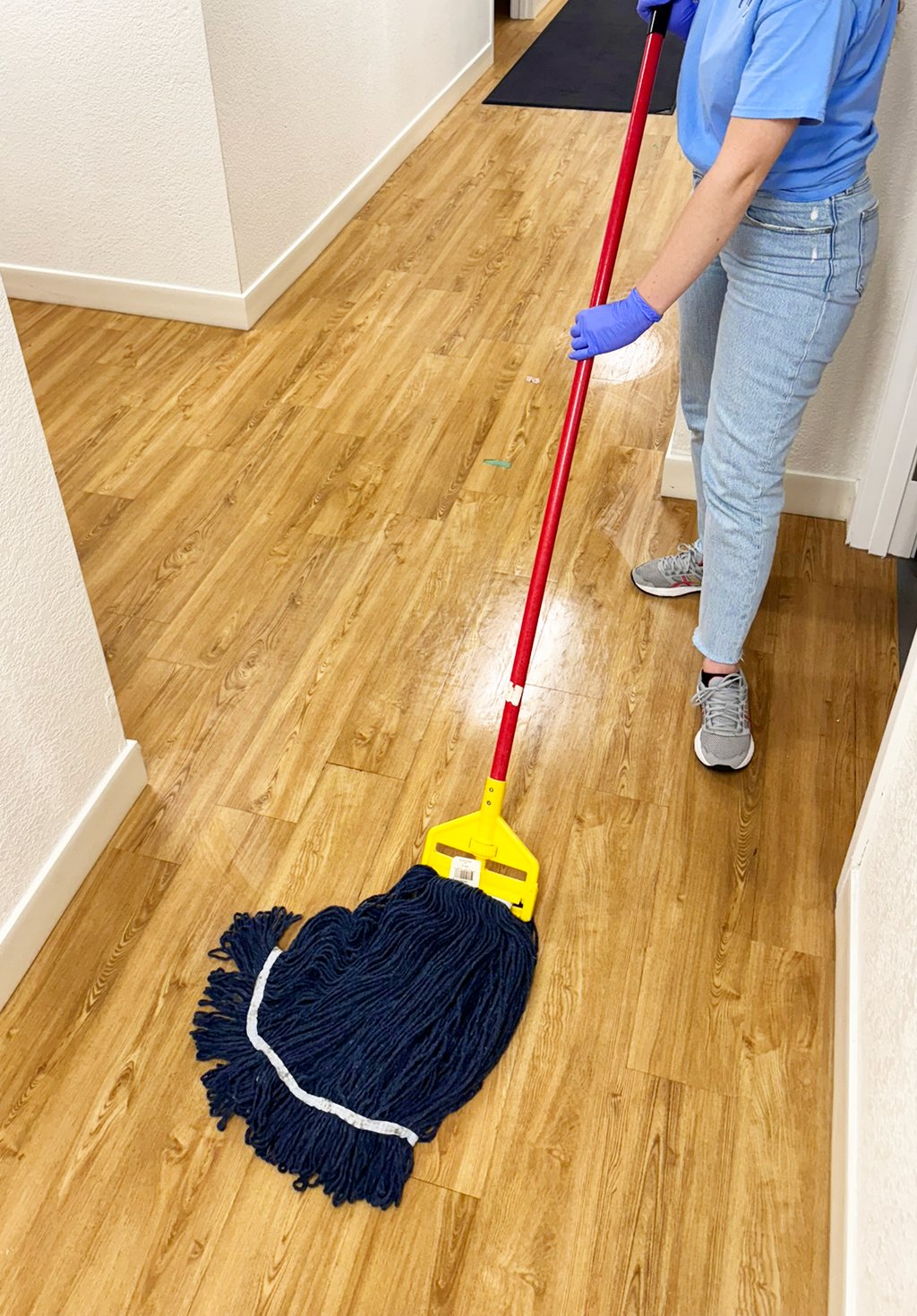 Lady cleaner from Chez Cleaning Services cleaning a floor with a mop
