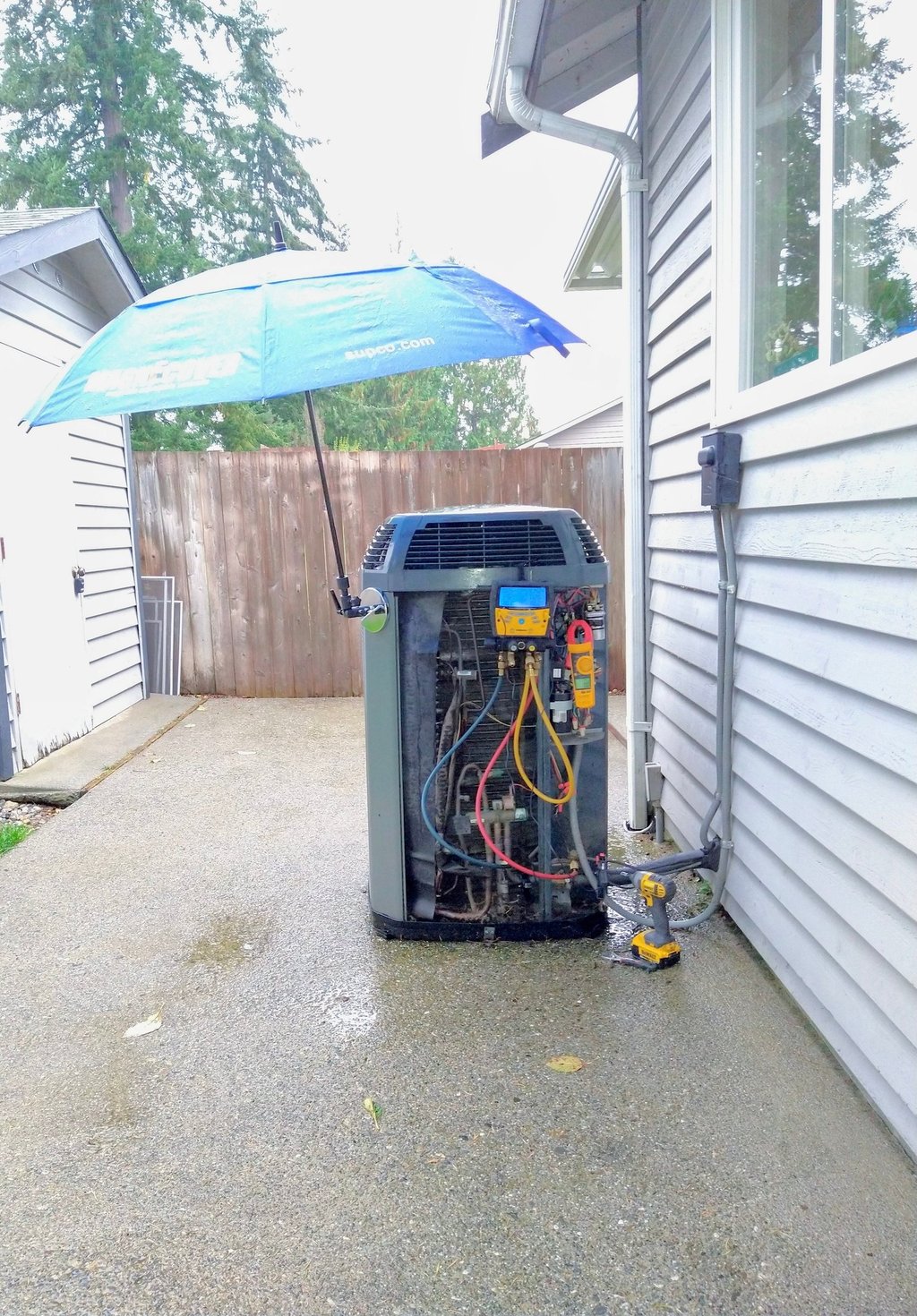 An outdoor HVAC system maintenance during a visit to our client making readings on the digital tool