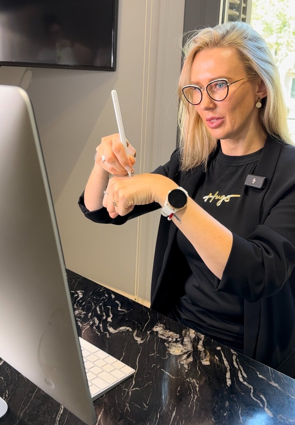 Darina sentada en un escritorio con un lápiz en la mano.