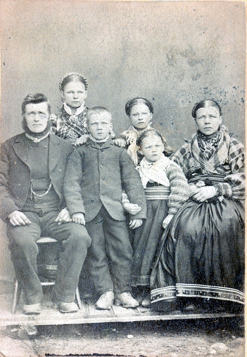 A bearded man, his wife, three daughters and one son in traditional dress circa 1890s