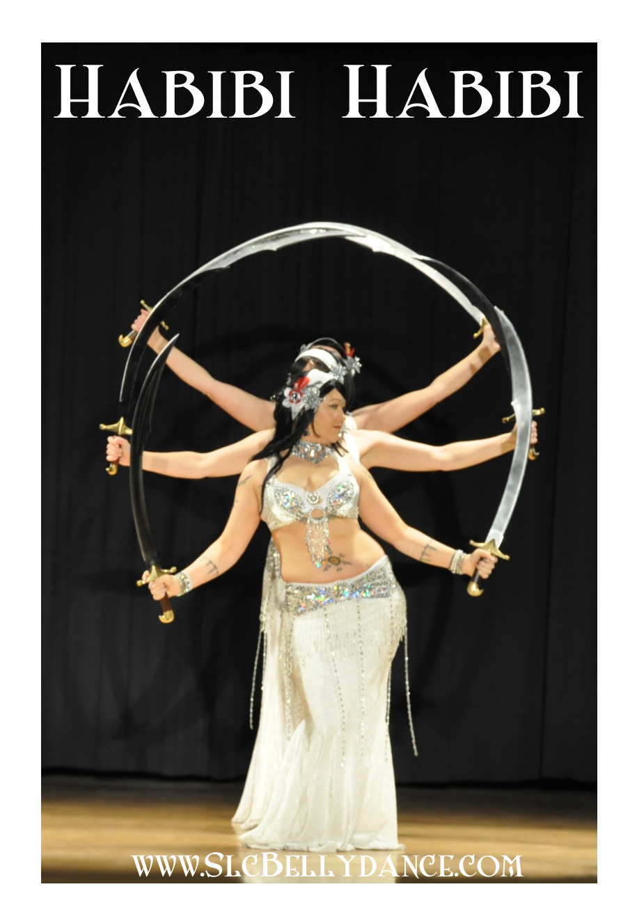 Shahravar and troupe Habibi Habibi of SLC dancing with double scimitars wearing white costumes