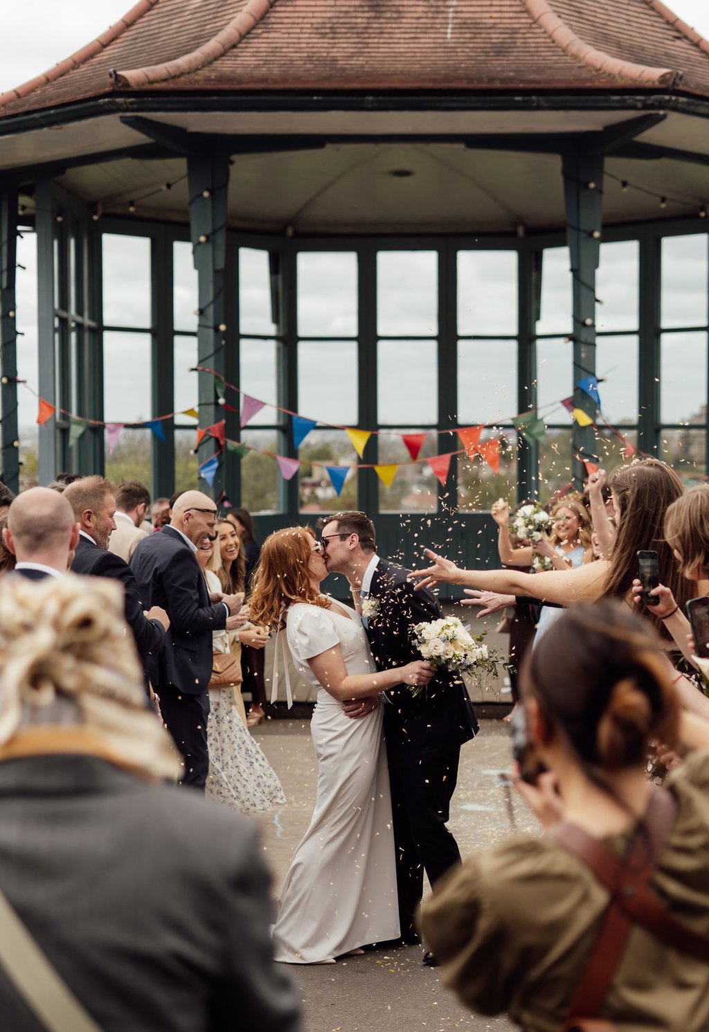 bride and groom are kissing with sunglasses 