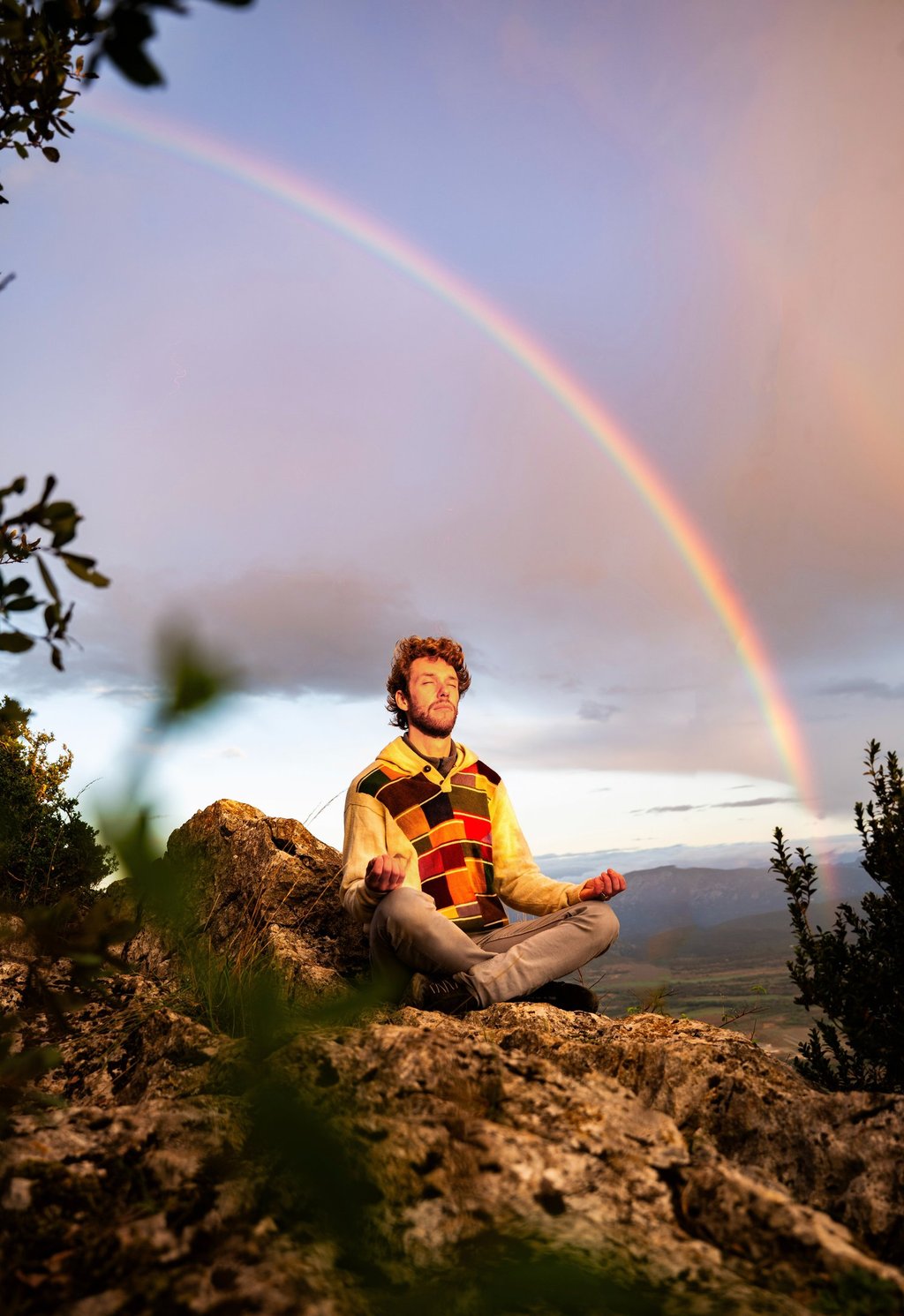 Monsieur Rêve pratique la méditation de pleine conscience au sommet d'une montagne rocheuse
