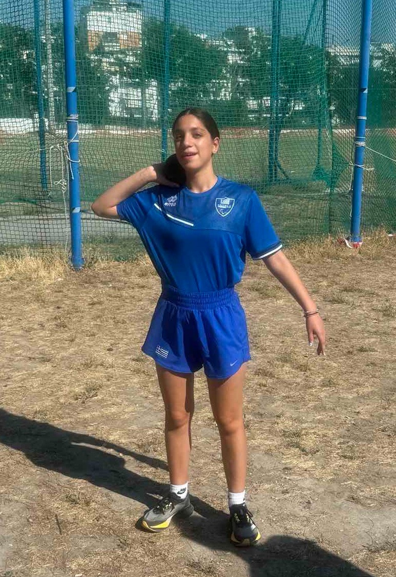 a woman in a blue shirt and shorts playing soccer