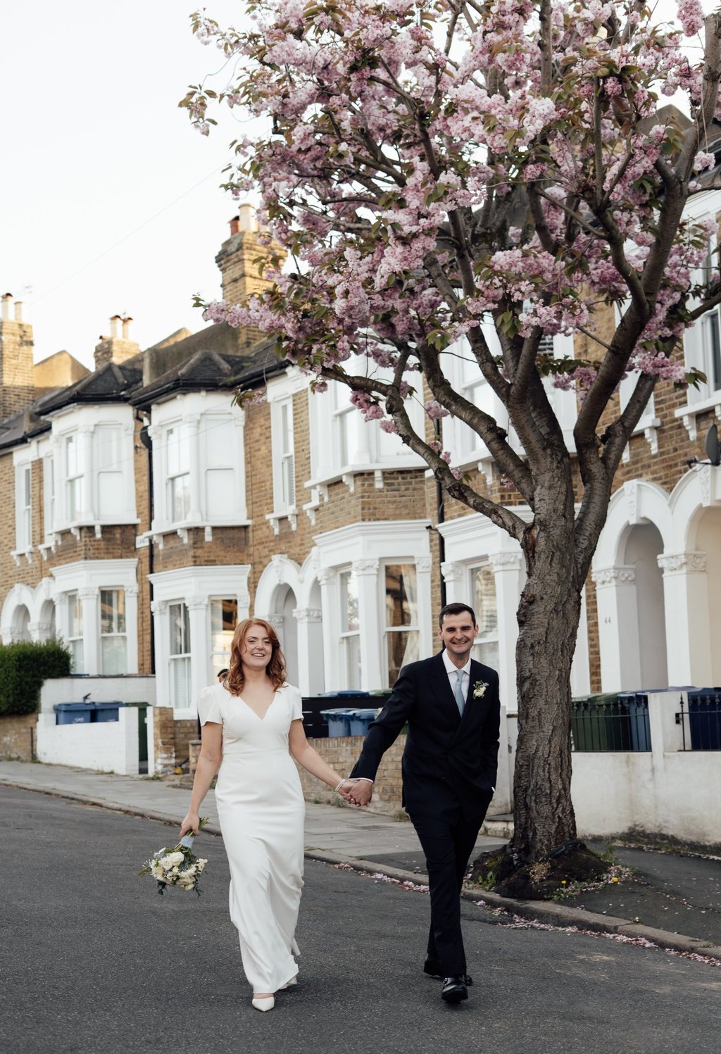 wedding couple walking down the street smiling
