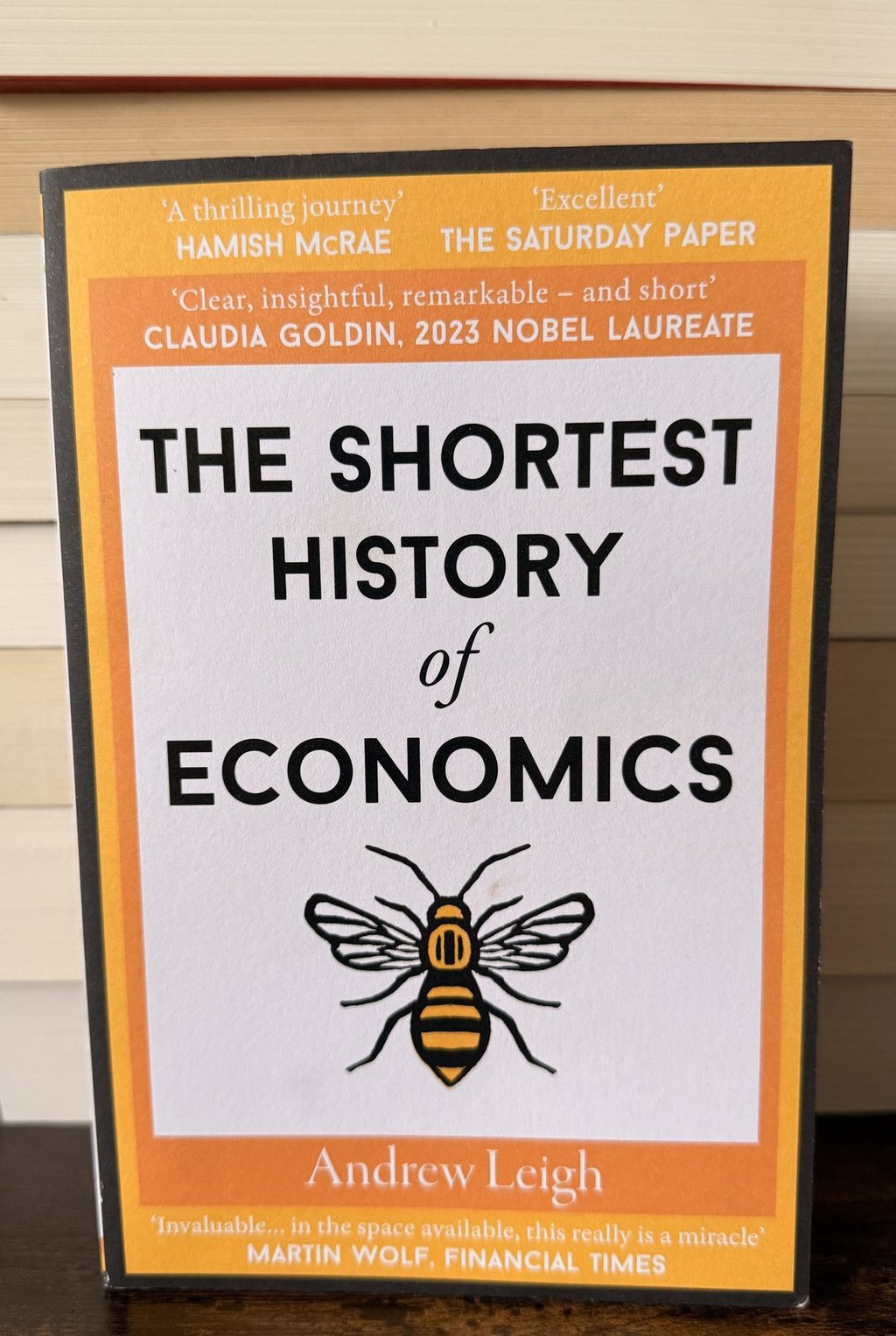 The Shortest History of Economics book cover by Andrew Leigh featuring a bee illustration.