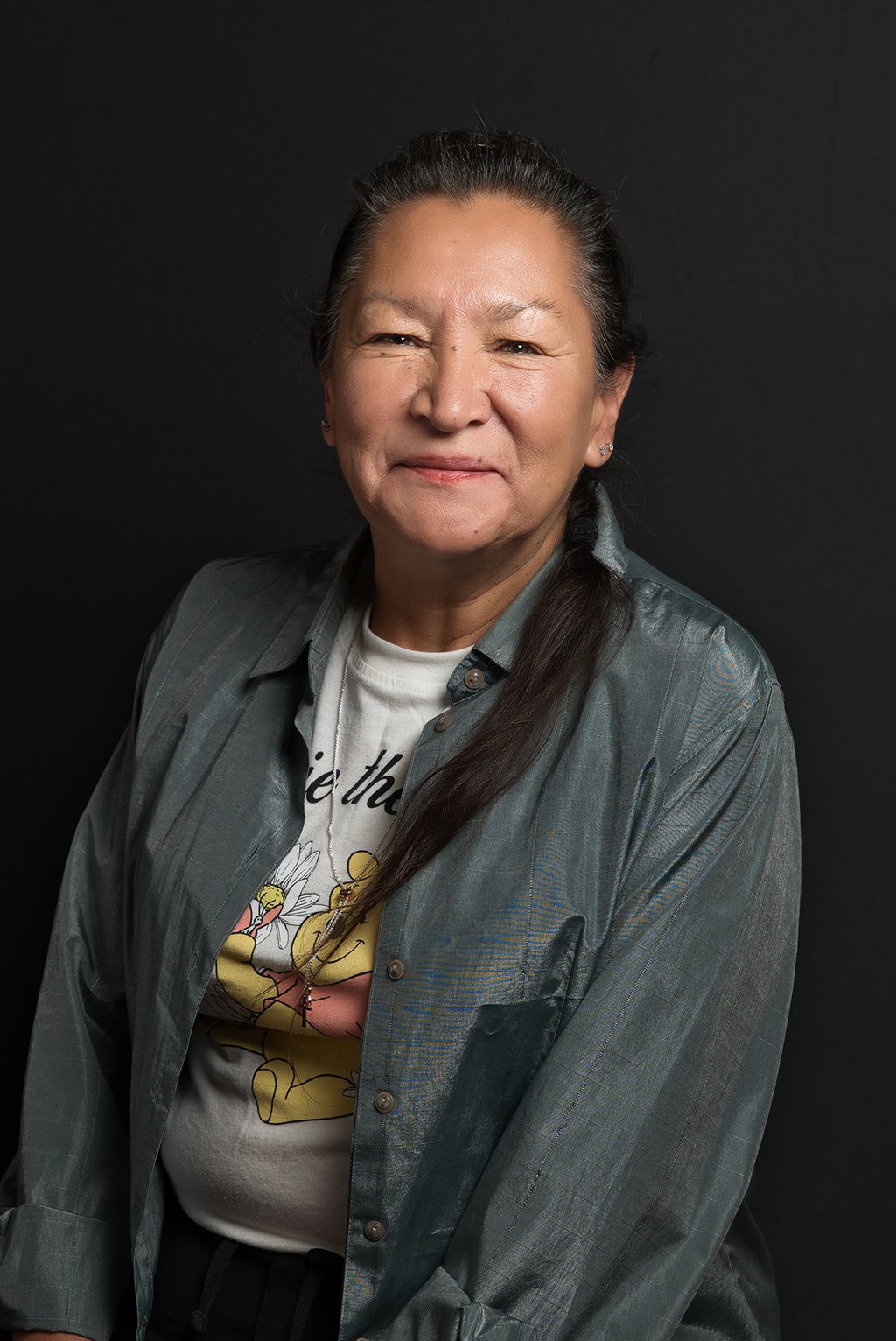 a female Native American with long hair and necklace smiling