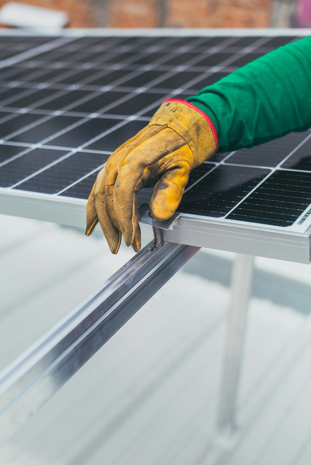 a person wearing gloves and gloves holding a solar panel