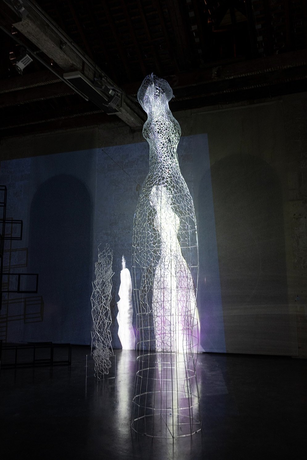 Video mapping on a large glass sculpture representing an human form