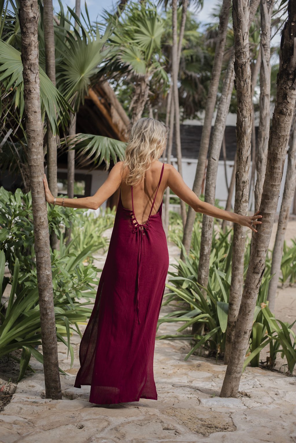 mujer usando un vestido rojo boho chic Tulum fondo de jungla
