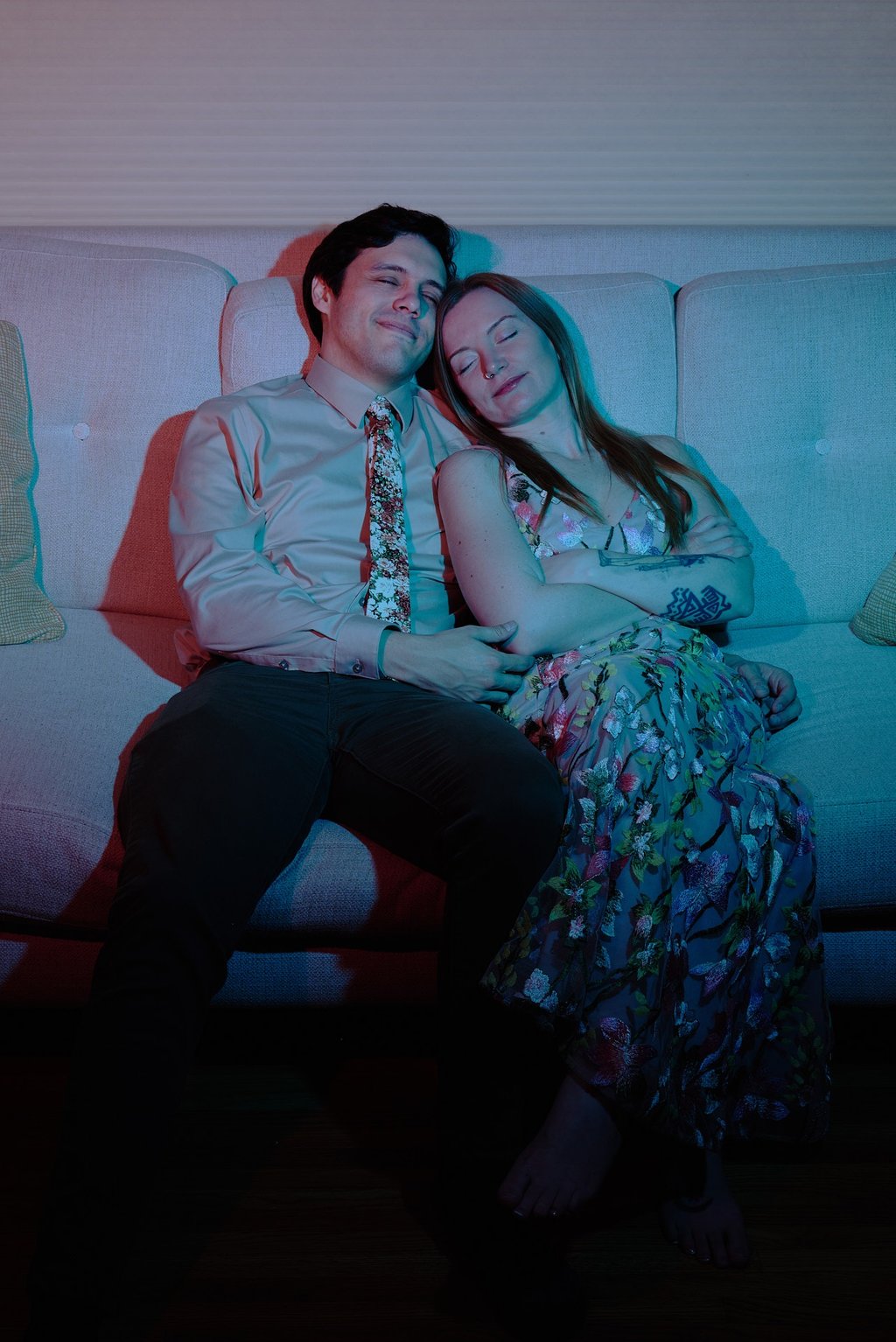 a man and woman sitting on a couch napping