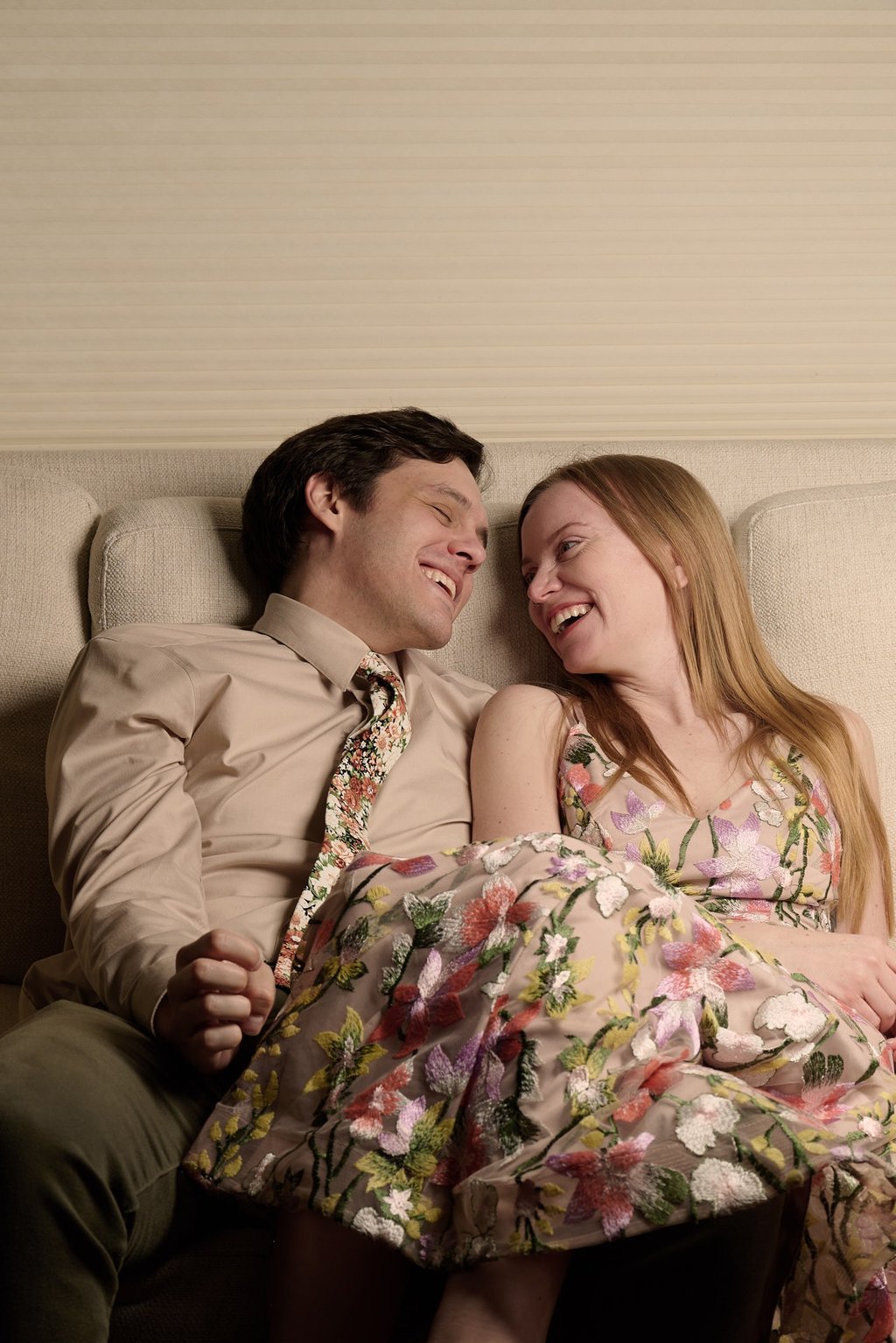 a man and woman sitting on a couch smiling at each other