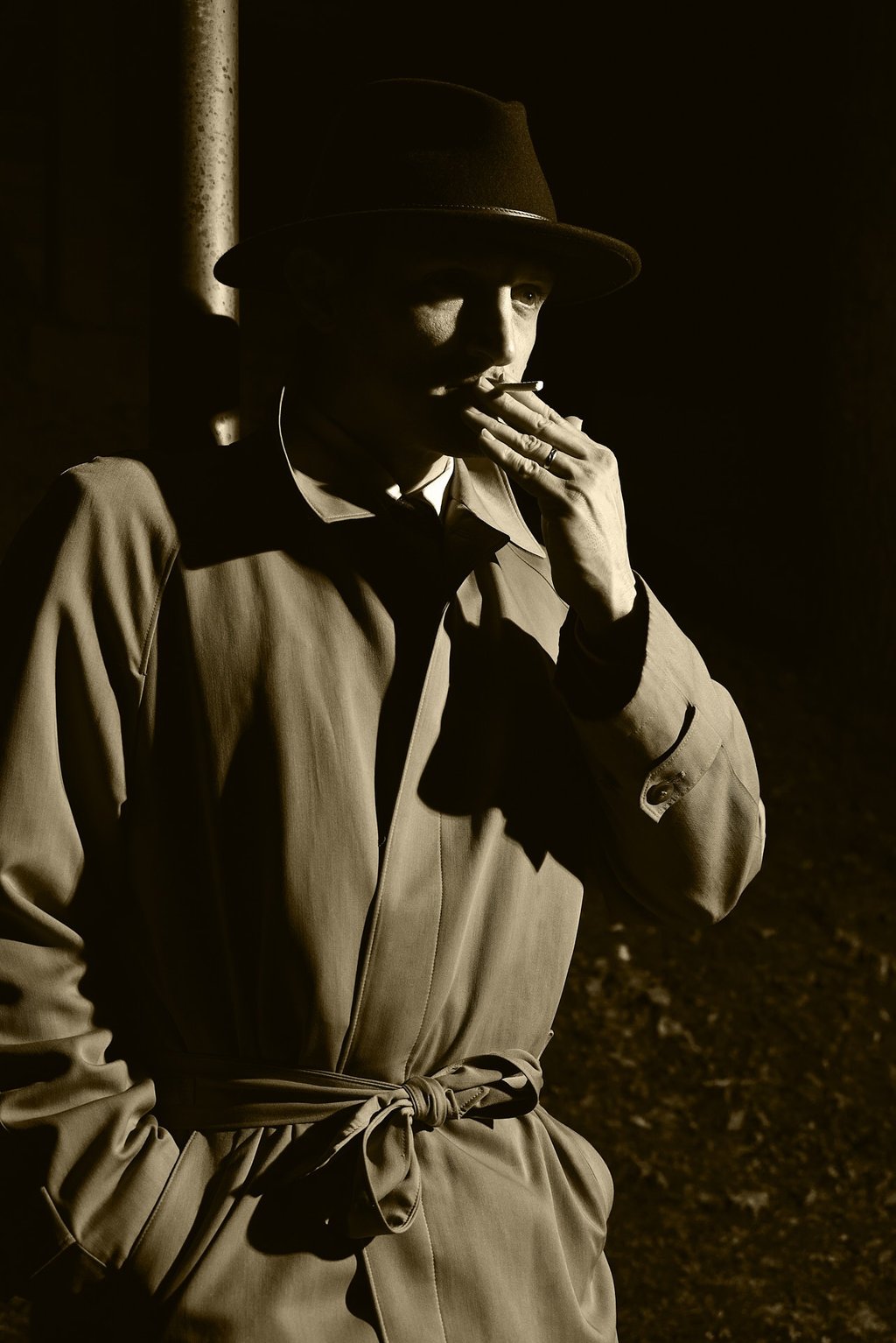 a man in a hat and rain jacket smoking