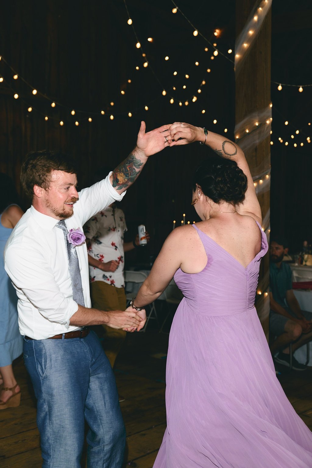 a man and woman in a purple dress dancing at a wedding reception