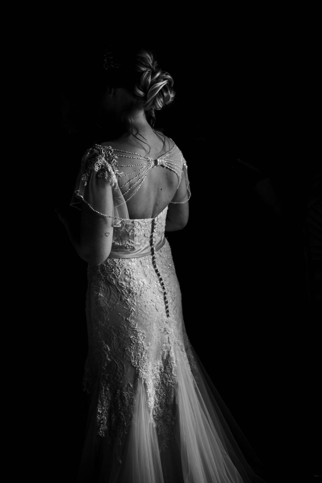 a bride in a wedding dress standing in a black and white photo