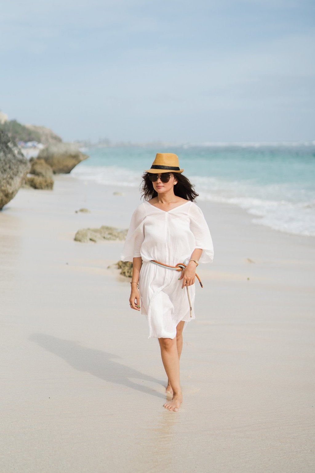 Mother walking alone along the beach at Karma Kandara Bali  