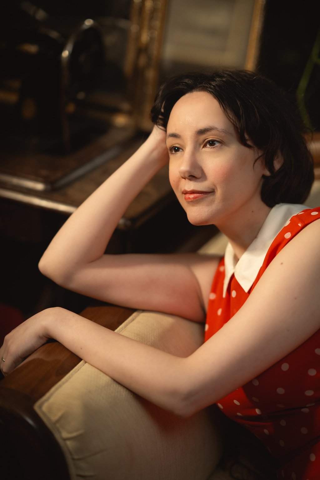 Maria in a read polkadot dress looking ahead