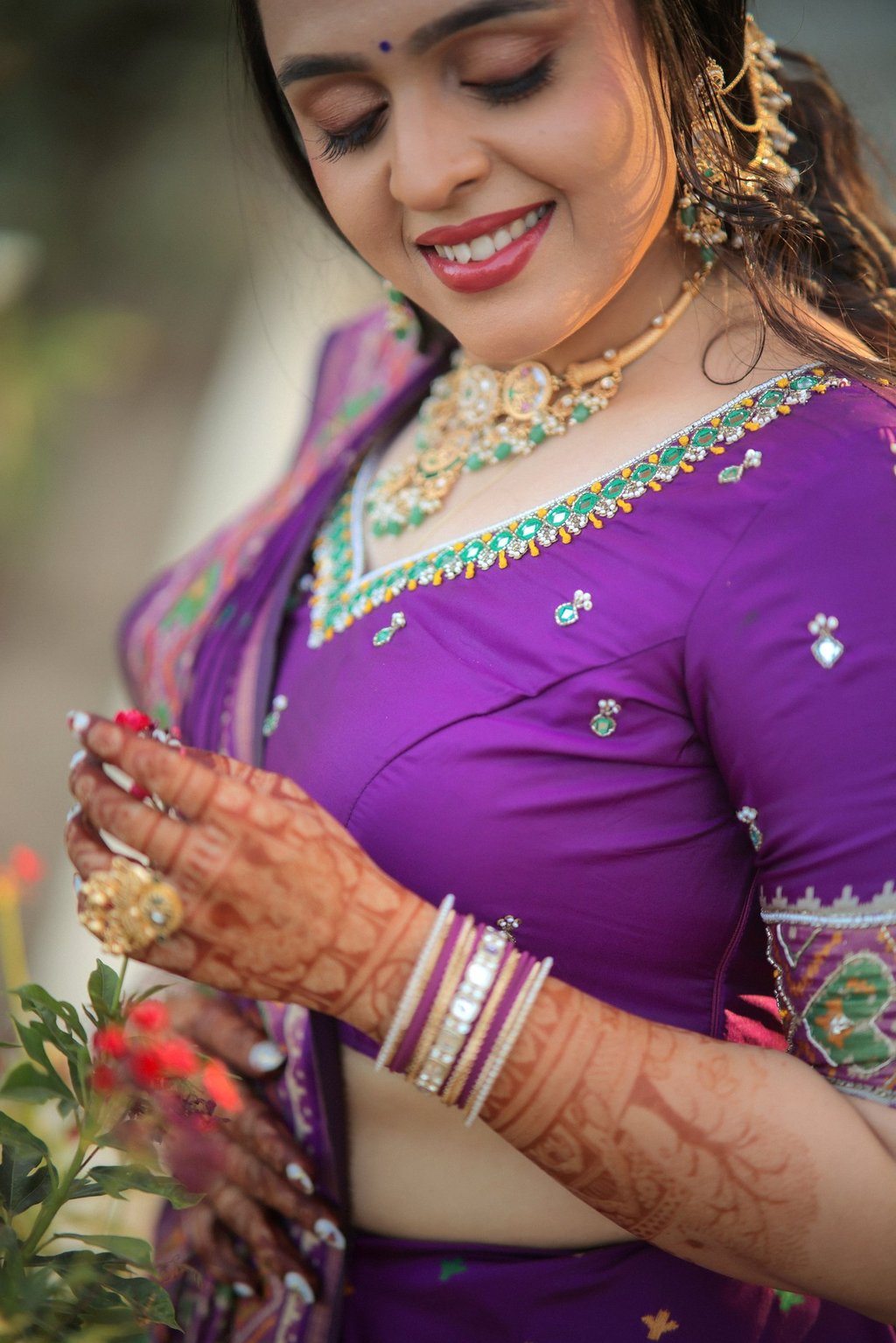 "Close-up of bridal mehendi hands with emerald kundan necklace and bangles — Indian bridal jewelry s