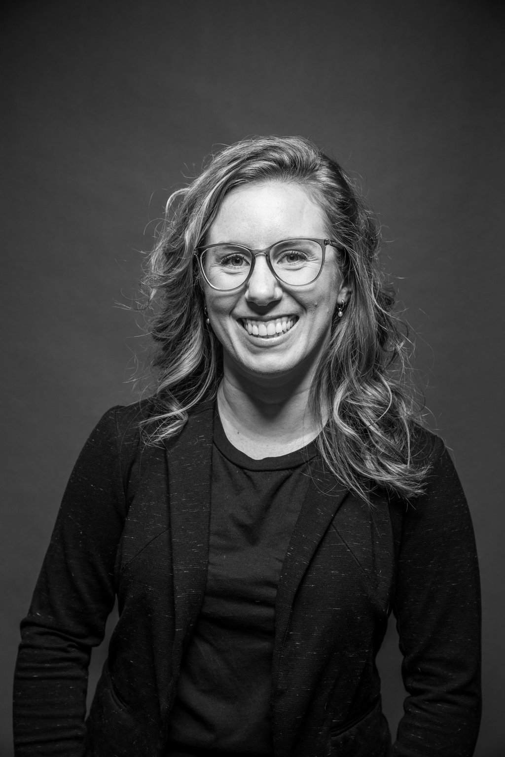 Miriam, une artiste maquilleuse qui sourit en noir et blanc