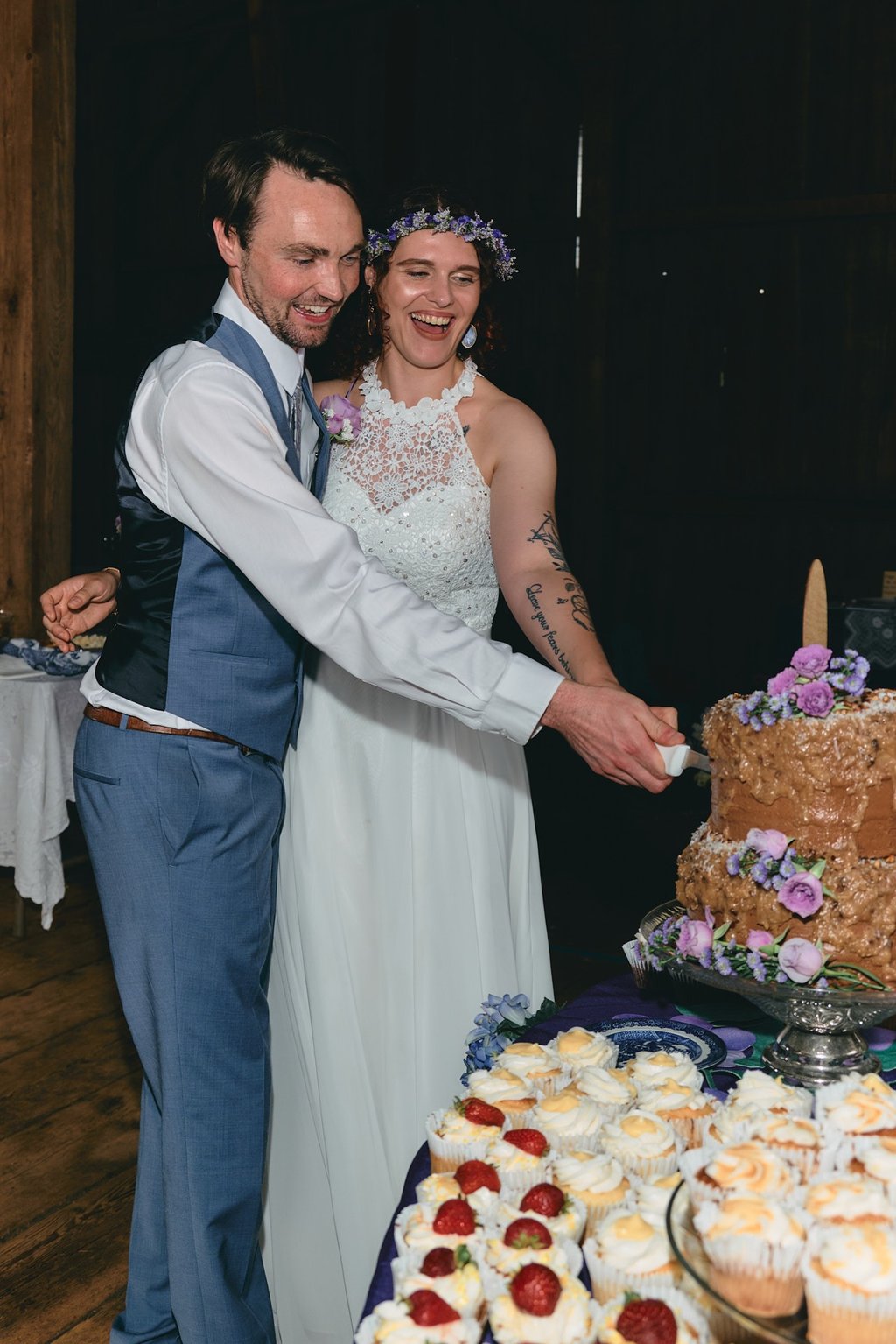 a bride and groom are cutting into a wedding cake