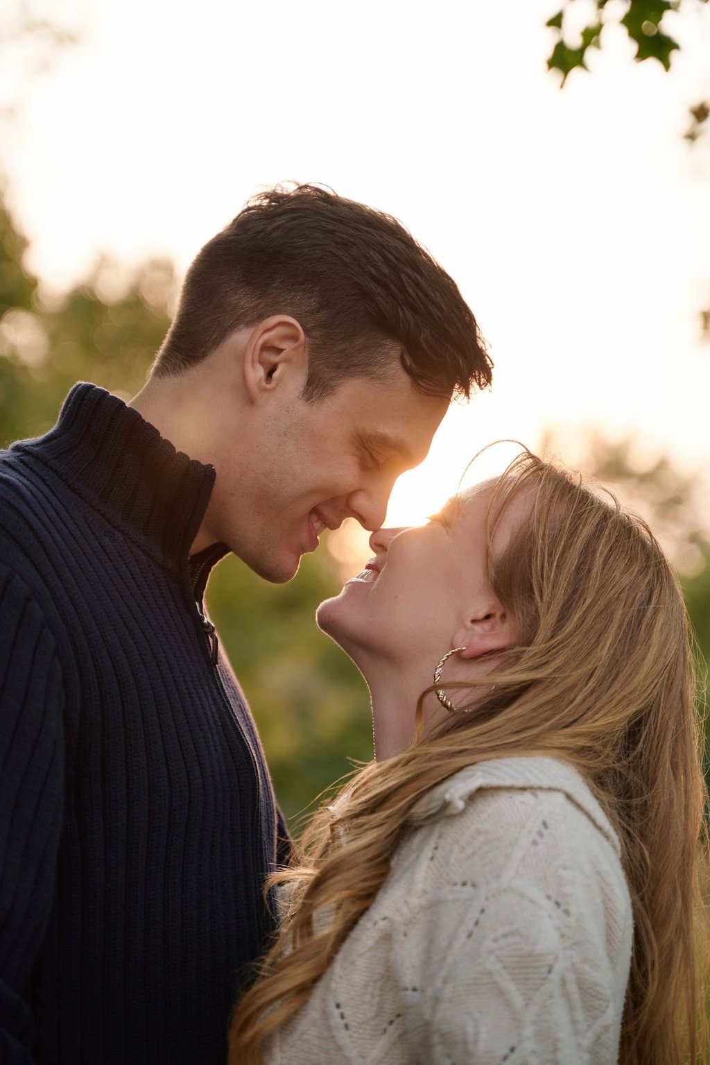 a man and woman are kissing in front of the sunset