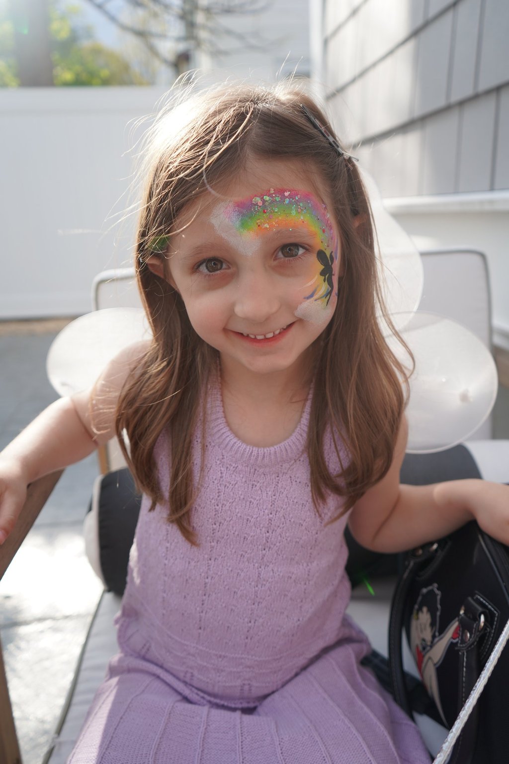Showing off her rainbow face paint
