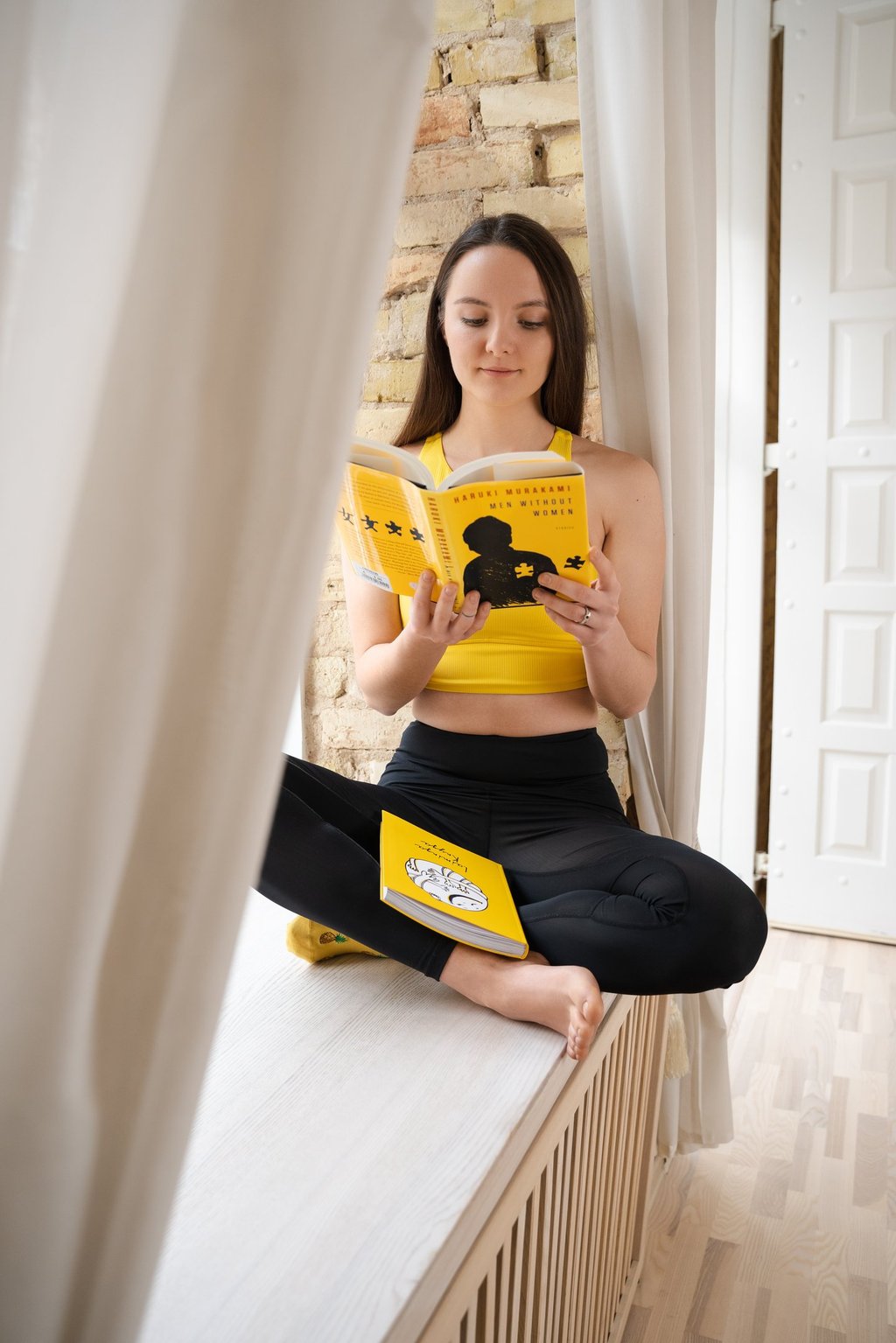 a woman sitting on a bench reading a book