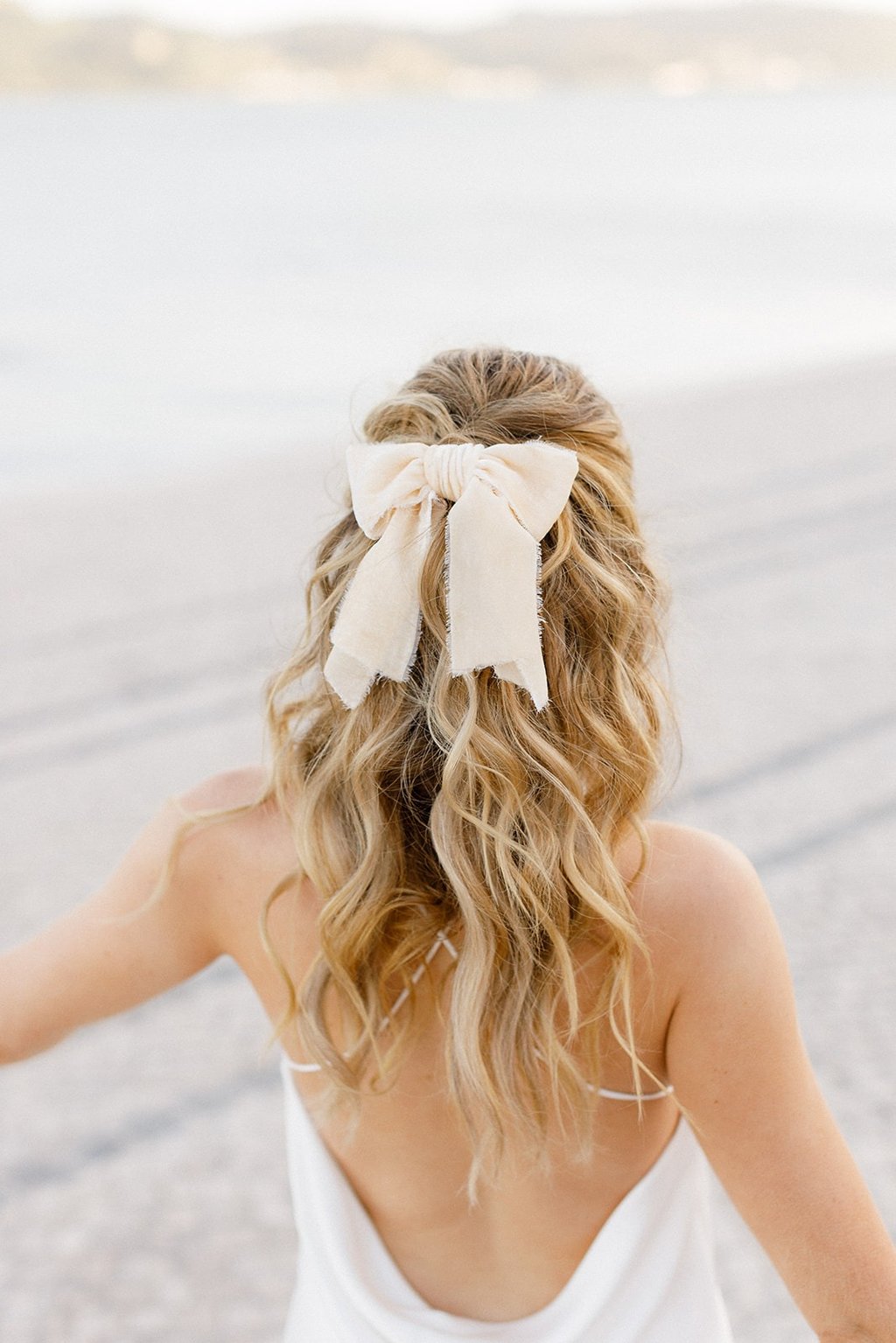 Blonde fashionista bride wears short wedding dress, silk hair bow and natural hair extensions