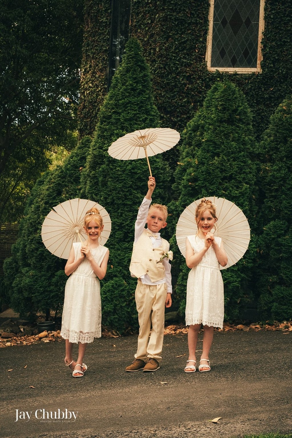 Children holding parasols at Avalon Castle Melbourne wedding outdoor ceremony momentChildren holding