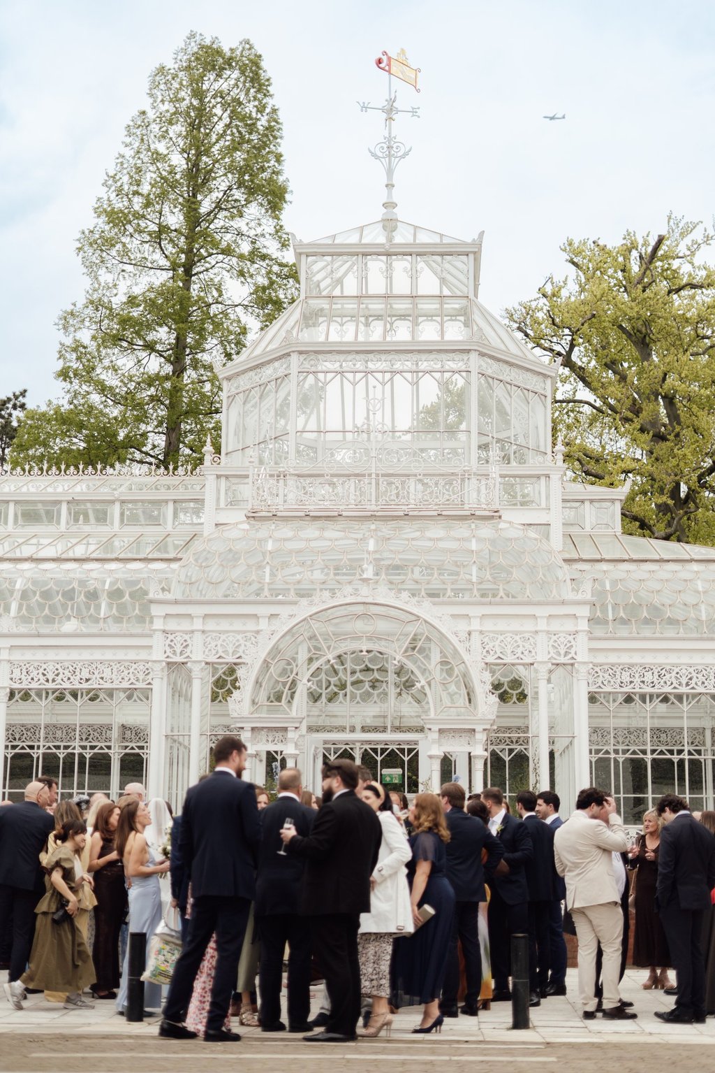 photograph of a wedding venue with wedding guests standing outside 