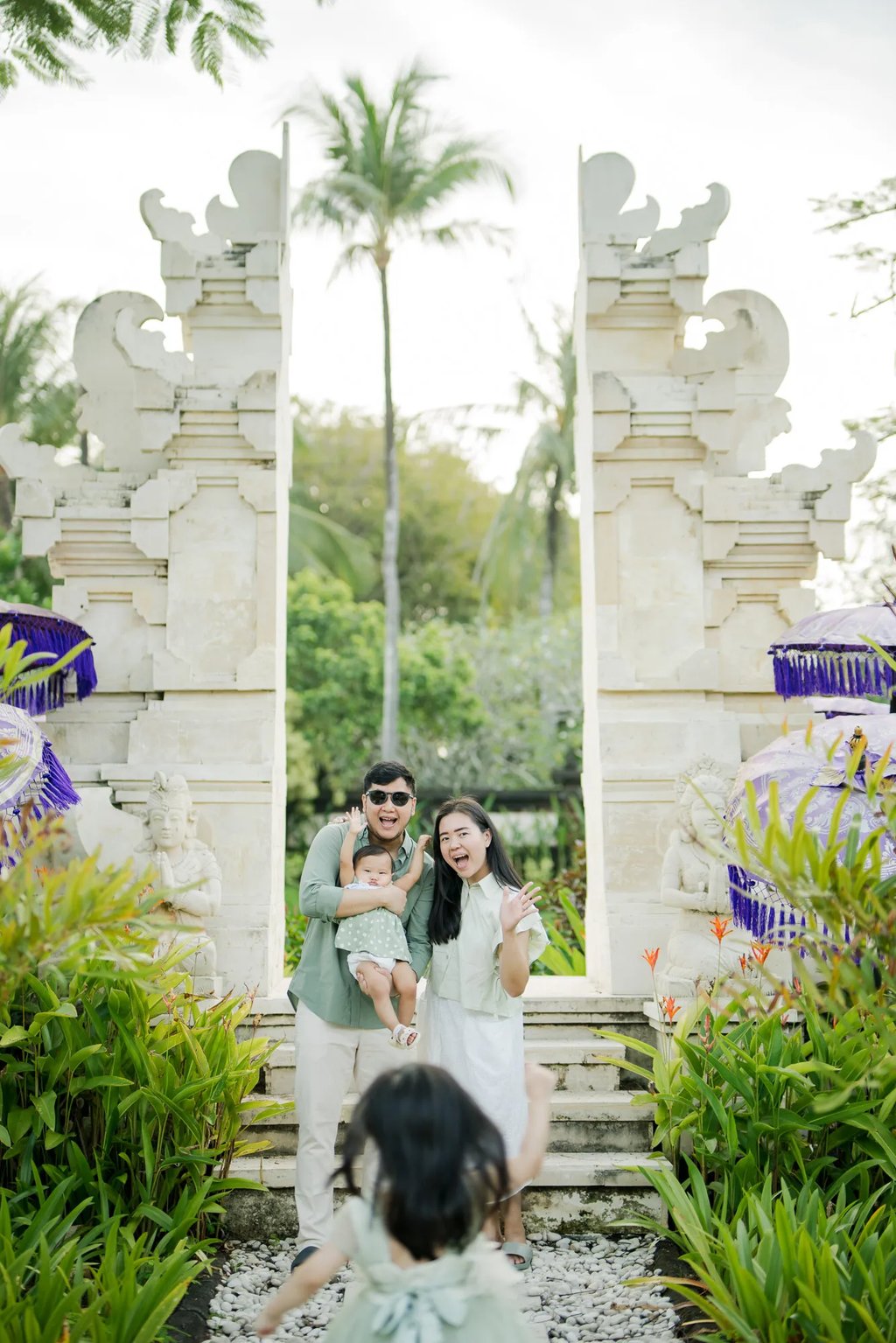 Family standing at a traditional Balinese gate during a family photography session in Nusa Dua Bali.